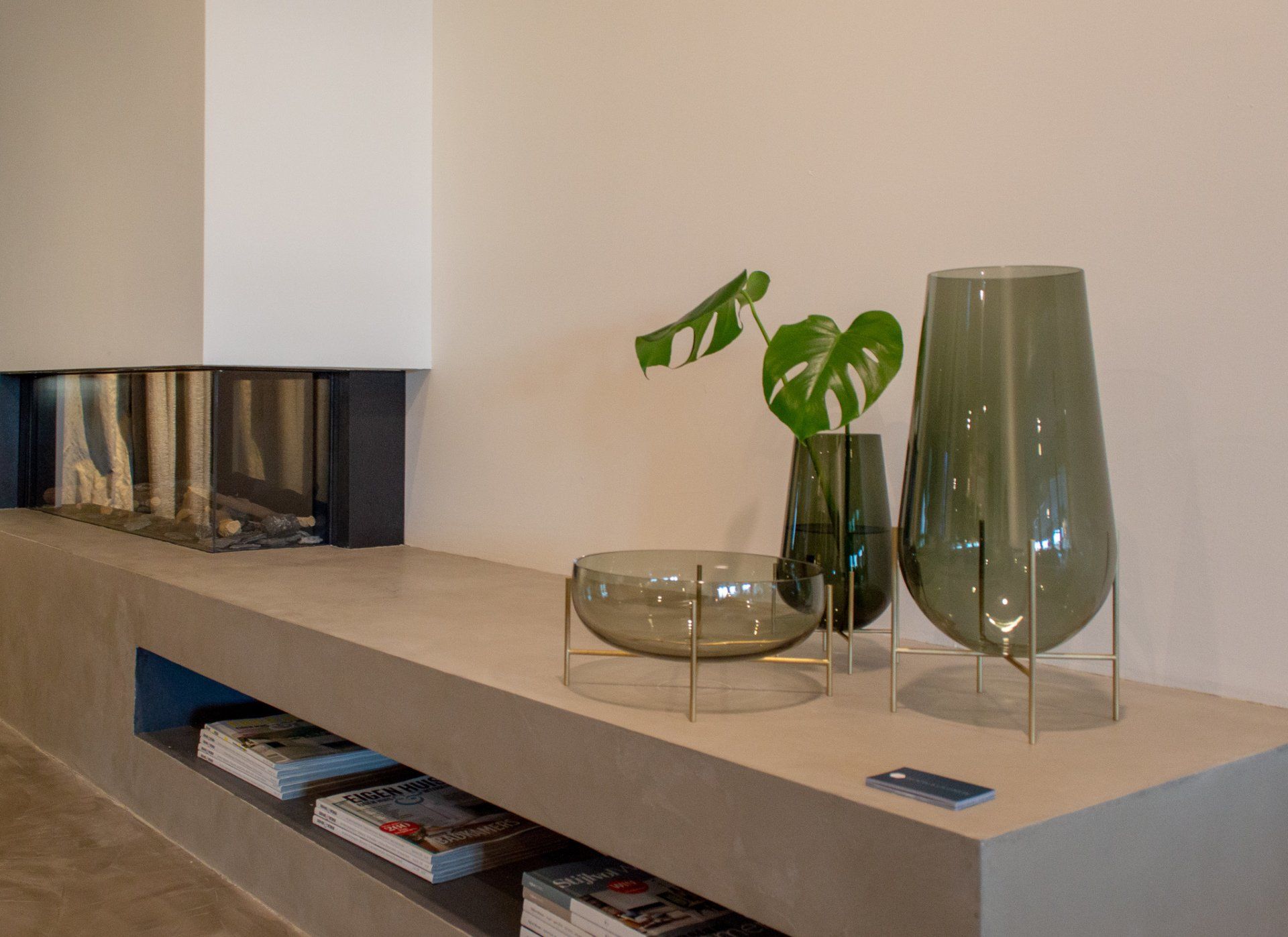 Een plank met vazen ​​en een schaal van 101CPH erop op plateau haard van Van Benthum Haarden.