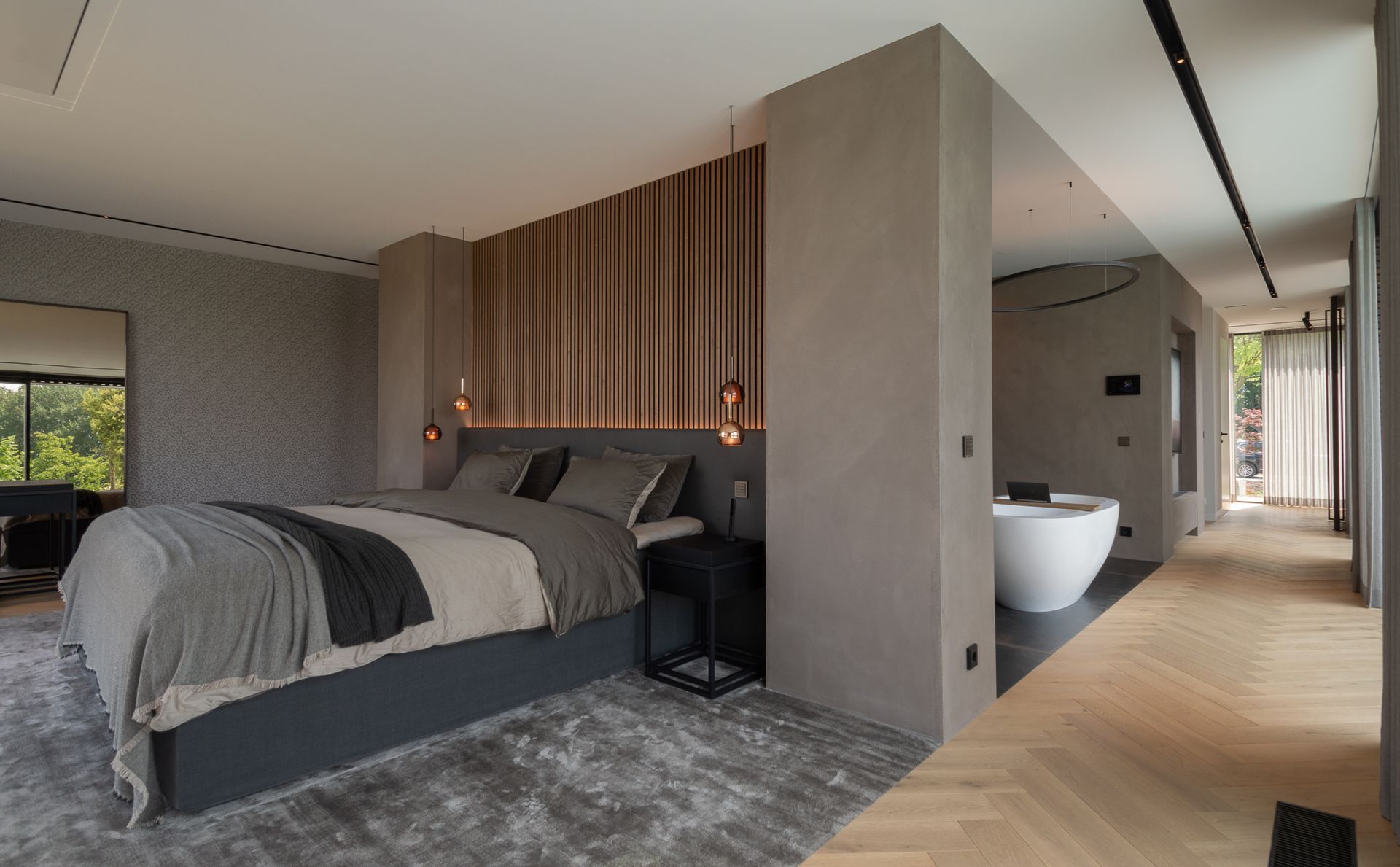 Een slaapkamer met een groot bed van Nilson Beds, tapijt van Jacaranda en een badkuip