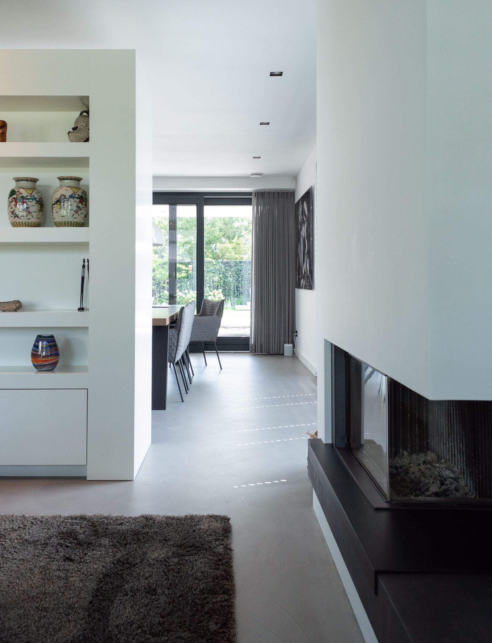 Een woonkamer met open haard van Van Benthum haarden en een tapijt