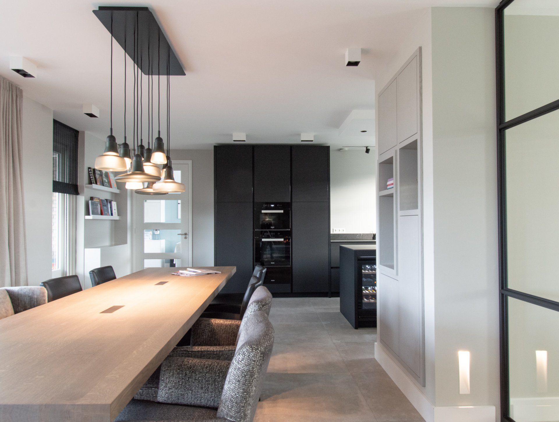 Een eetkamer met een lange tafel en stoelen