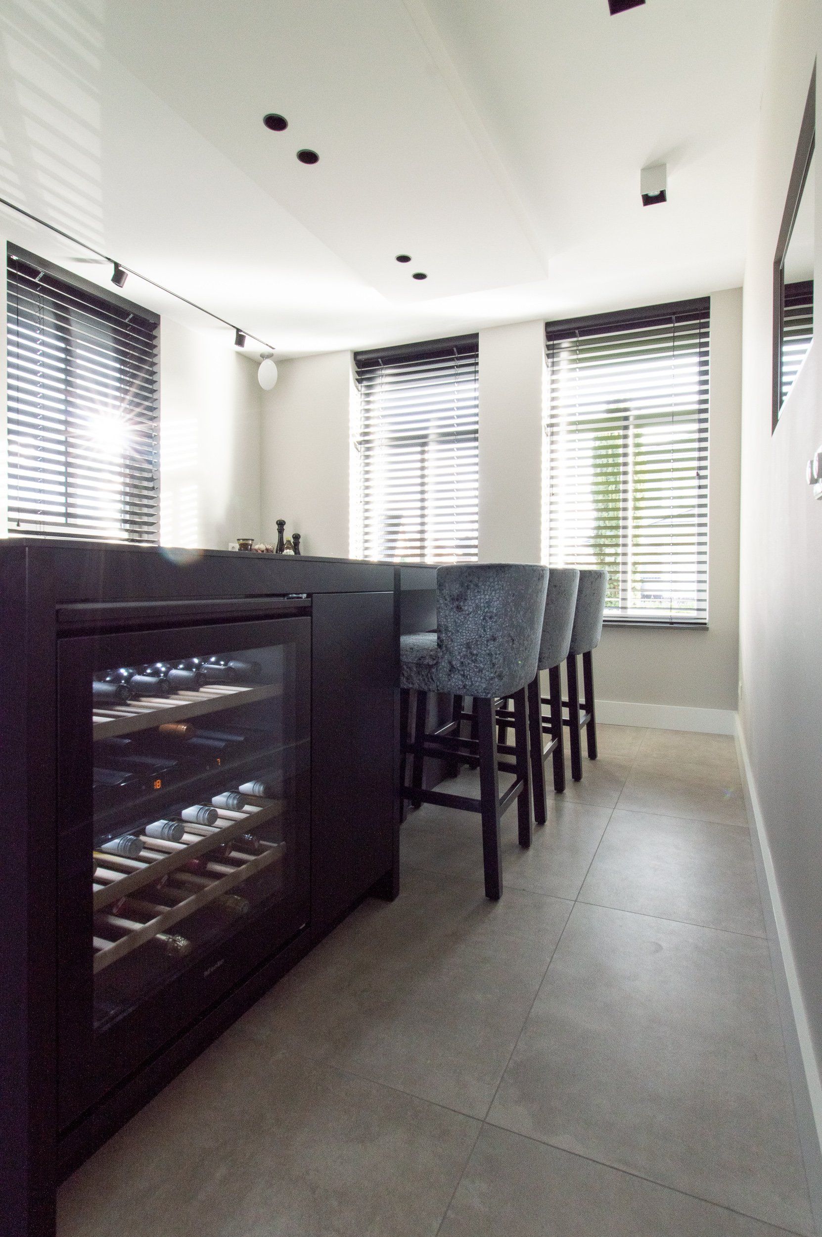 Een keuken met krukken en een wijnkoeler