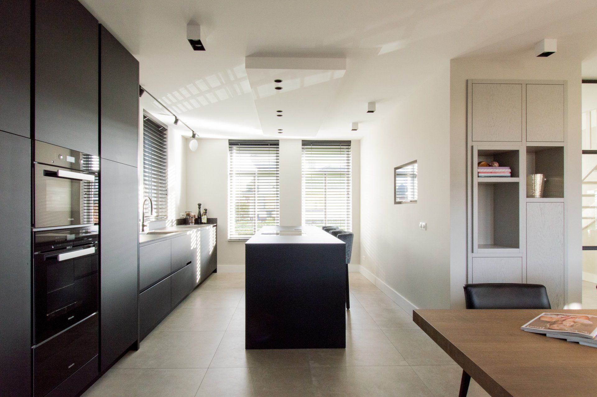 Een keuken met zwarte kasten en een groot kookeiland in het midden