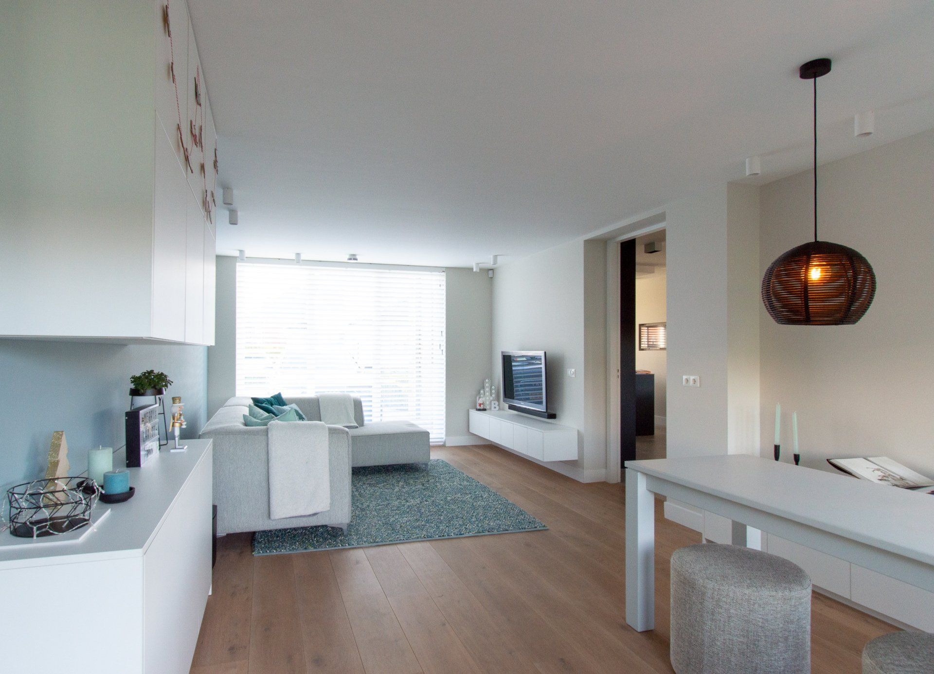 Een woonkamer met een witte bank en een witte tafel