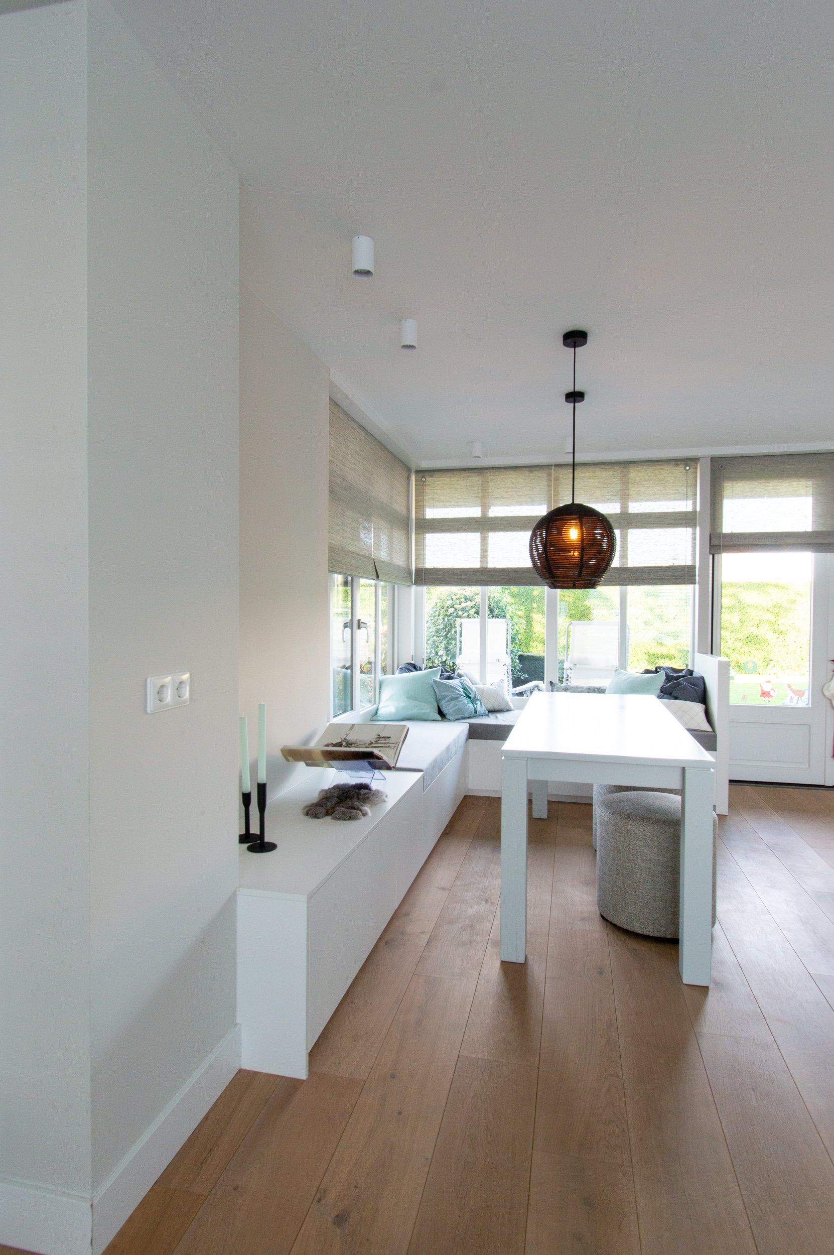 Een woonkamer met een tafel en een bank voor een raam.