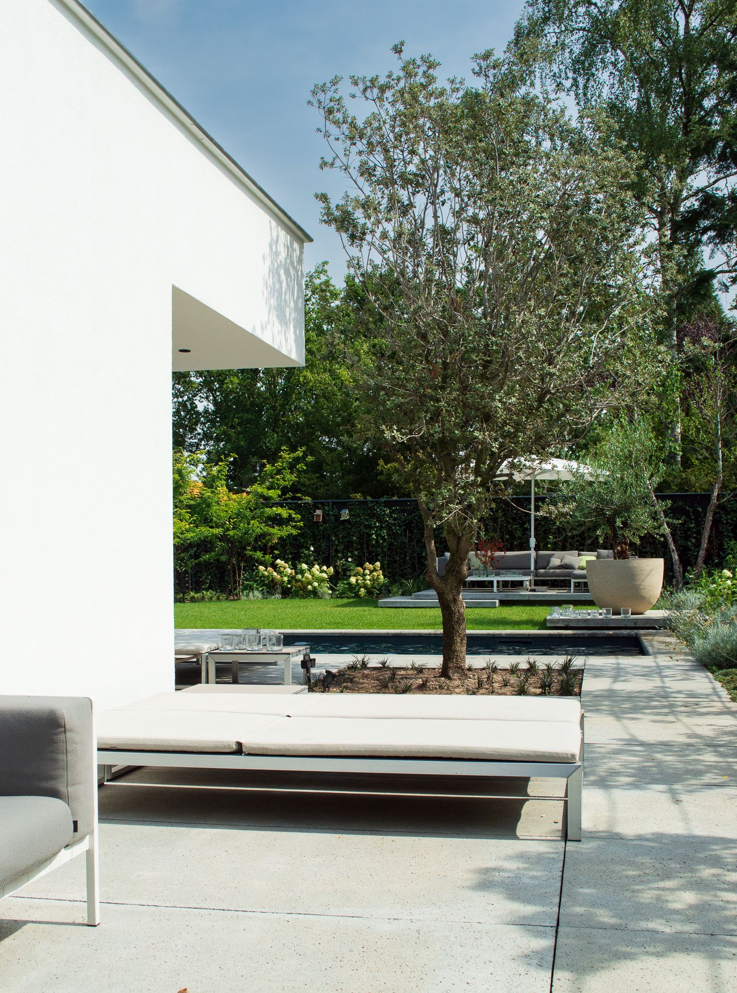 Een wit huis met een zwembad in de achtertuin