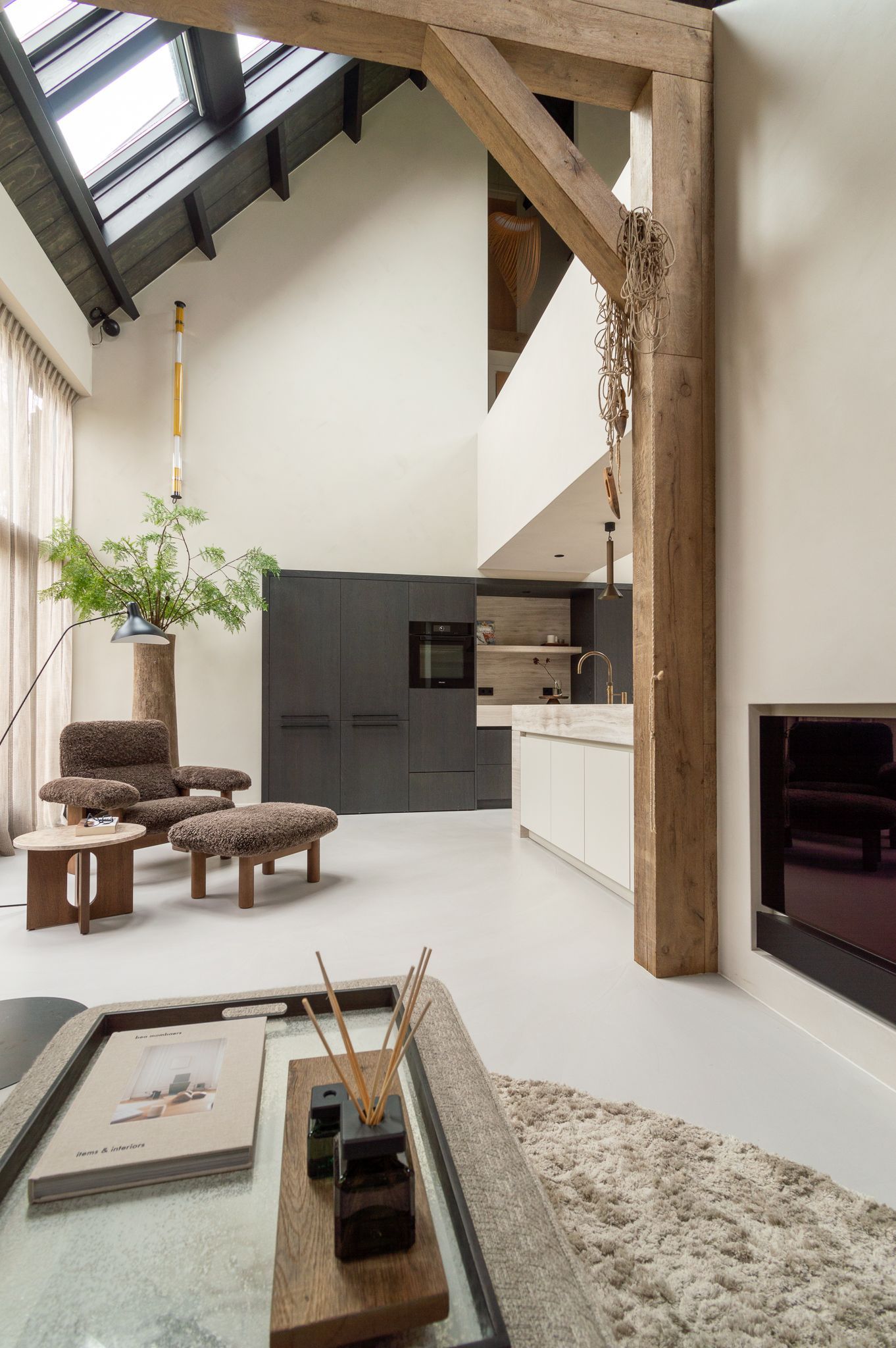 Een keuken met veel meubels van Audo en een open haard