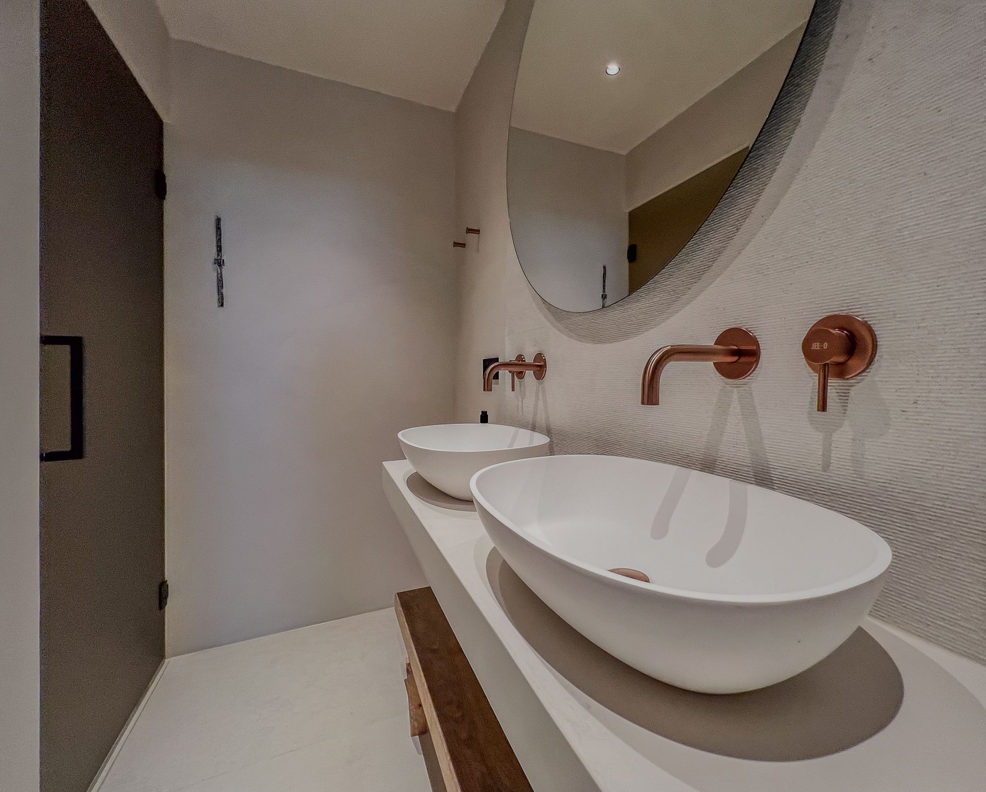 Een badkamer met twee wastafels en een spiegel van Jee-O