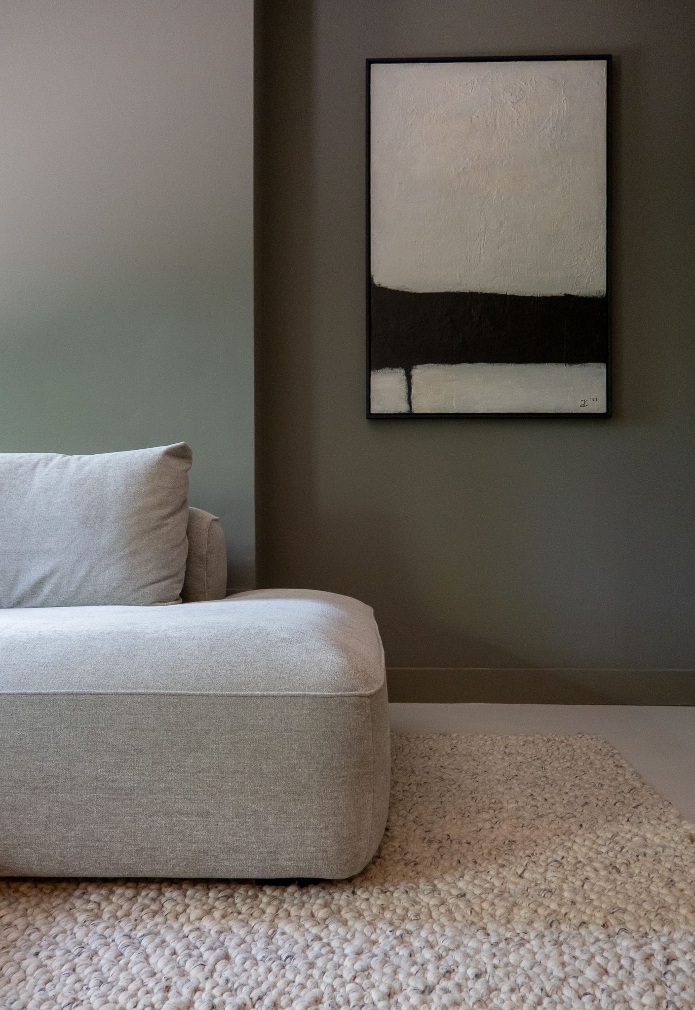 Een woonkamer met een bank en een kunstwerk van Jeroen Cornelisse van Artofnoise Guitars  aan de muur.