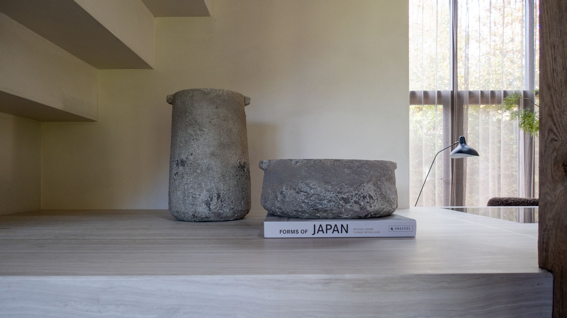 Twee vazen ​​van Serax staan ​​op een tafel naast een boek.