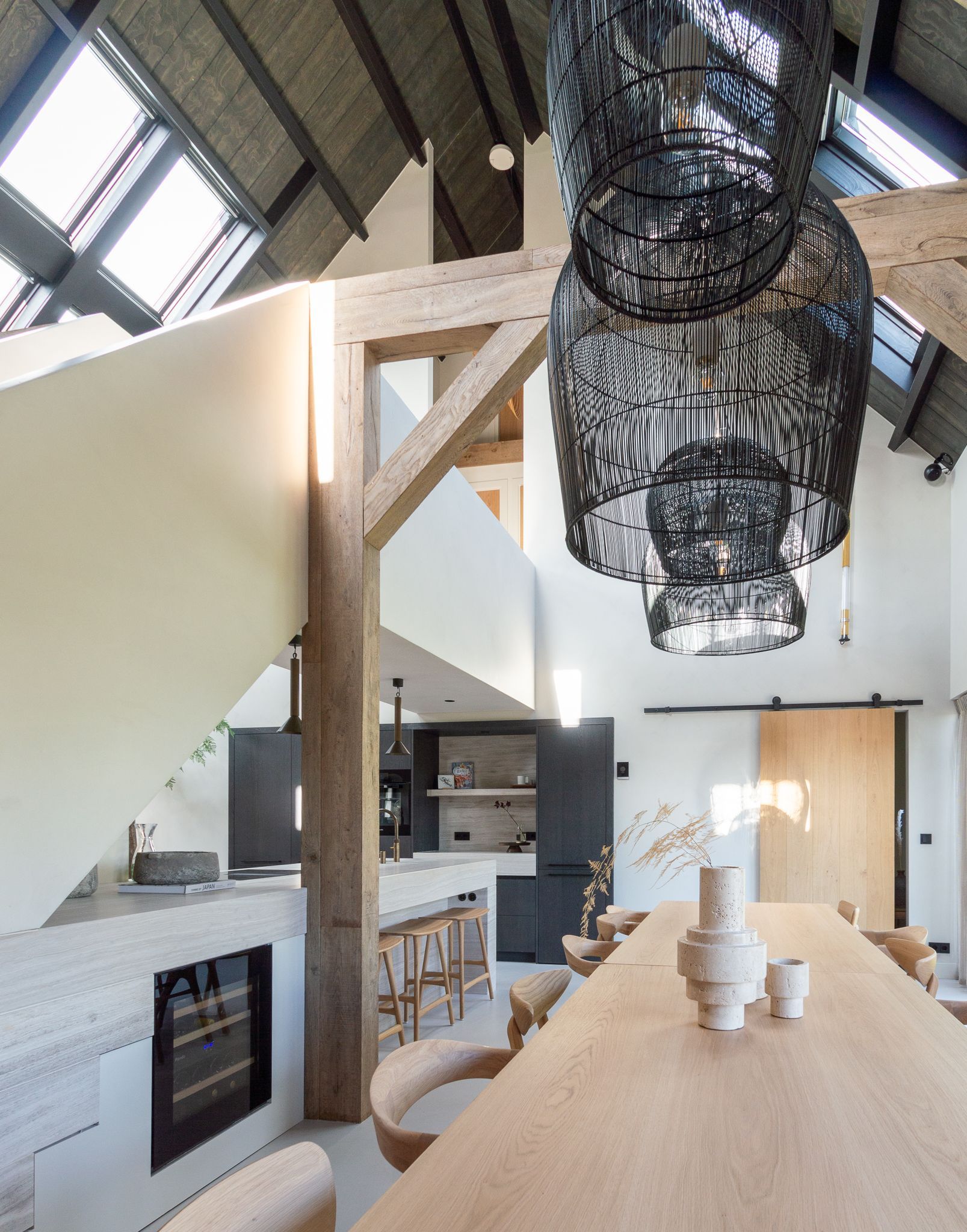 Een eetkamer met een lange houten tafel en stoelen