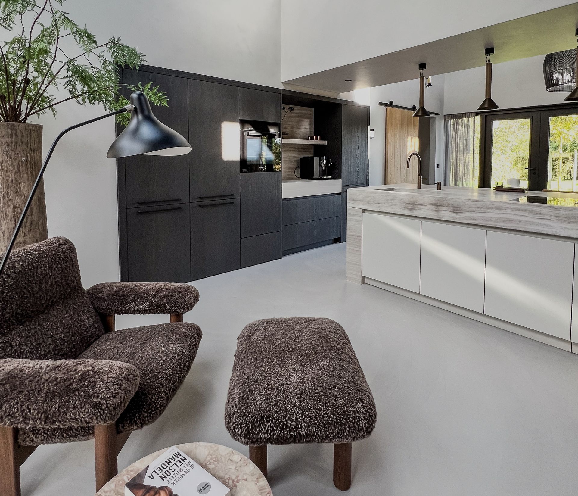 Een woonkamer met een fauteuil van het designmerk Audi en een tafel met daarop een boek