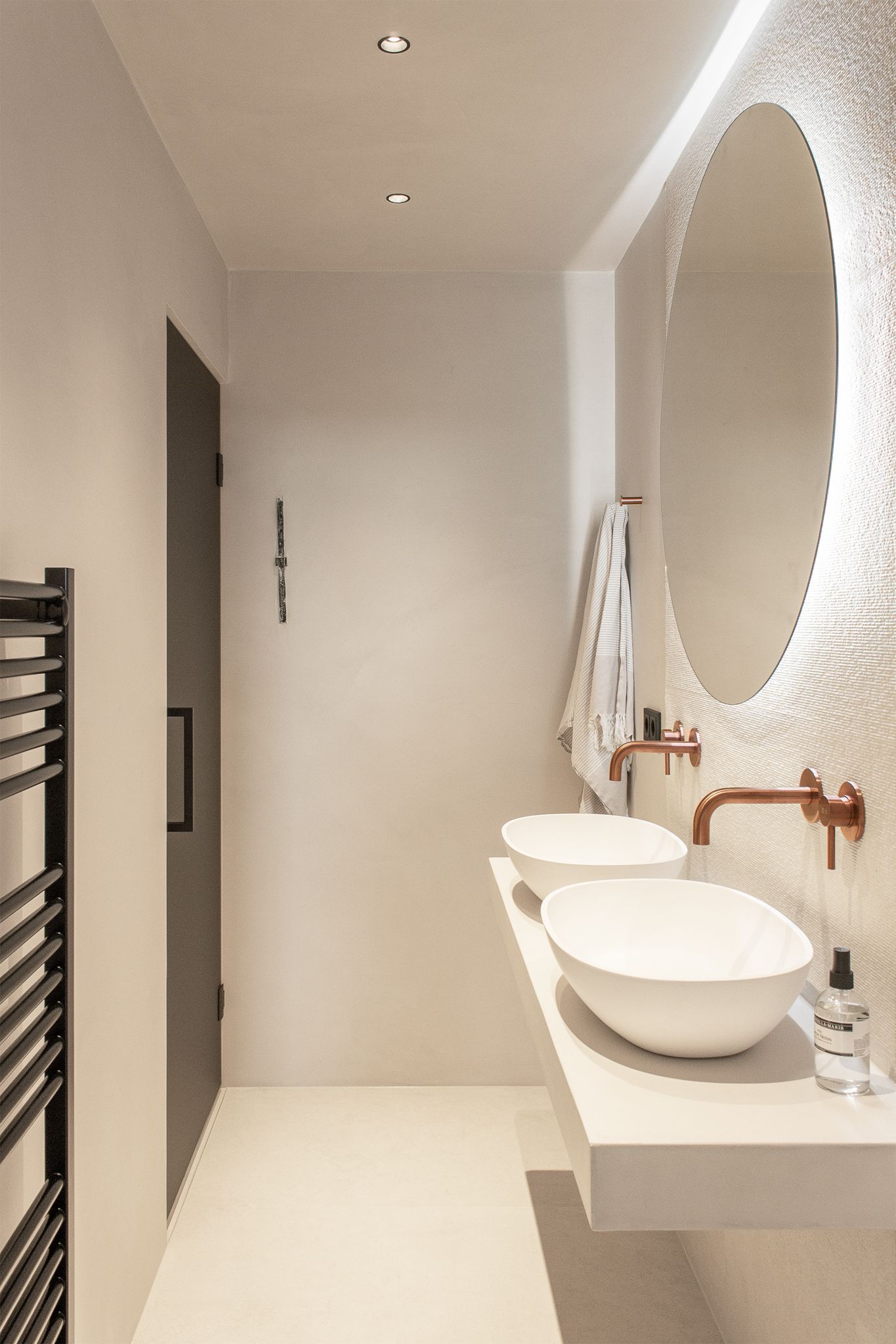 Een badkamer met twee wastafels, van Jee-O een spiegel en een handdoekenrek.