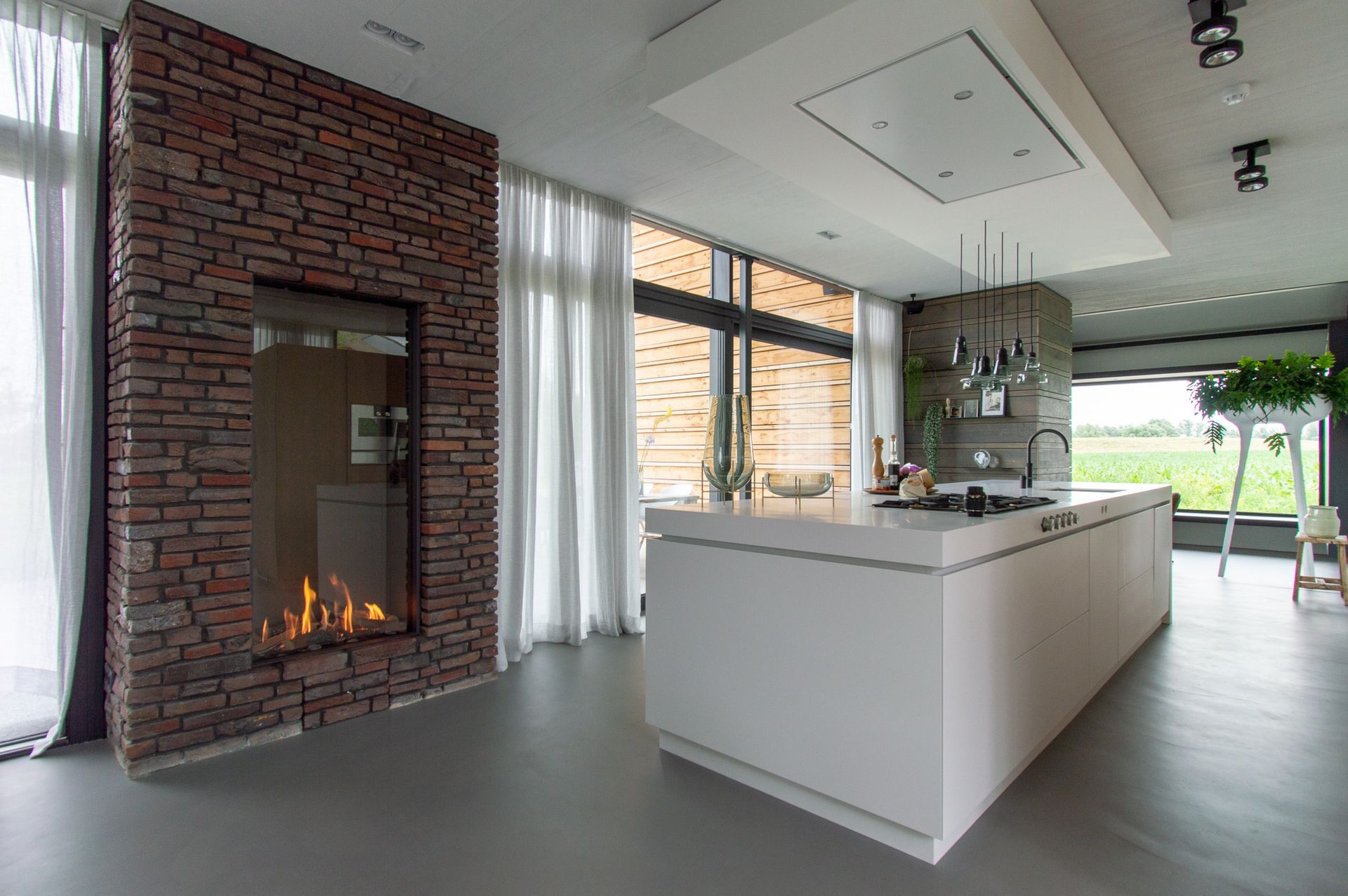 In het midden van de kamer in de keuken bevindt zich een open haard van Van Benthum Haarden.