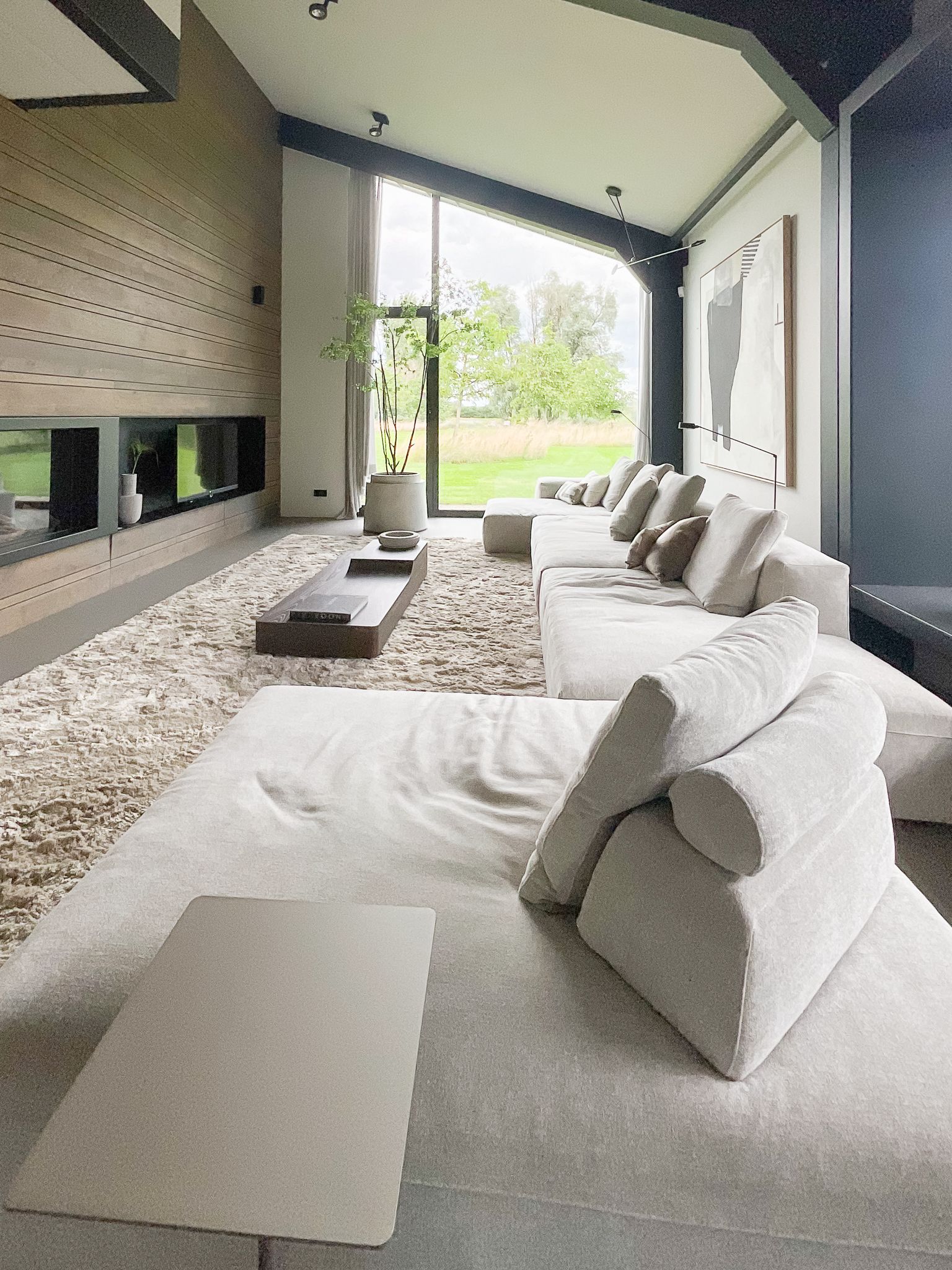 Een woonkamer met design bank van Frigerio en een groot raam