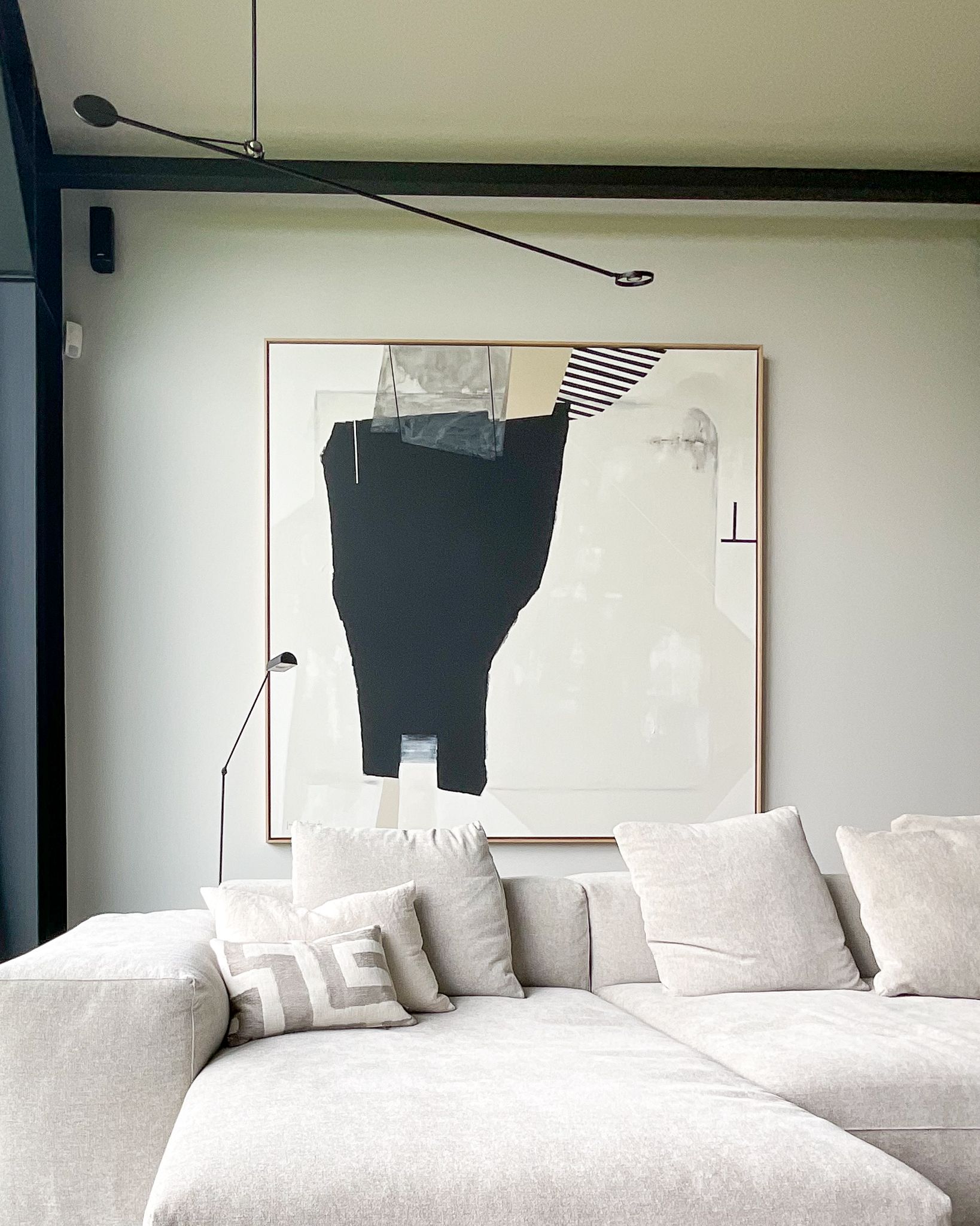 Een woonkamer met een bank en een schilderij aan de muur