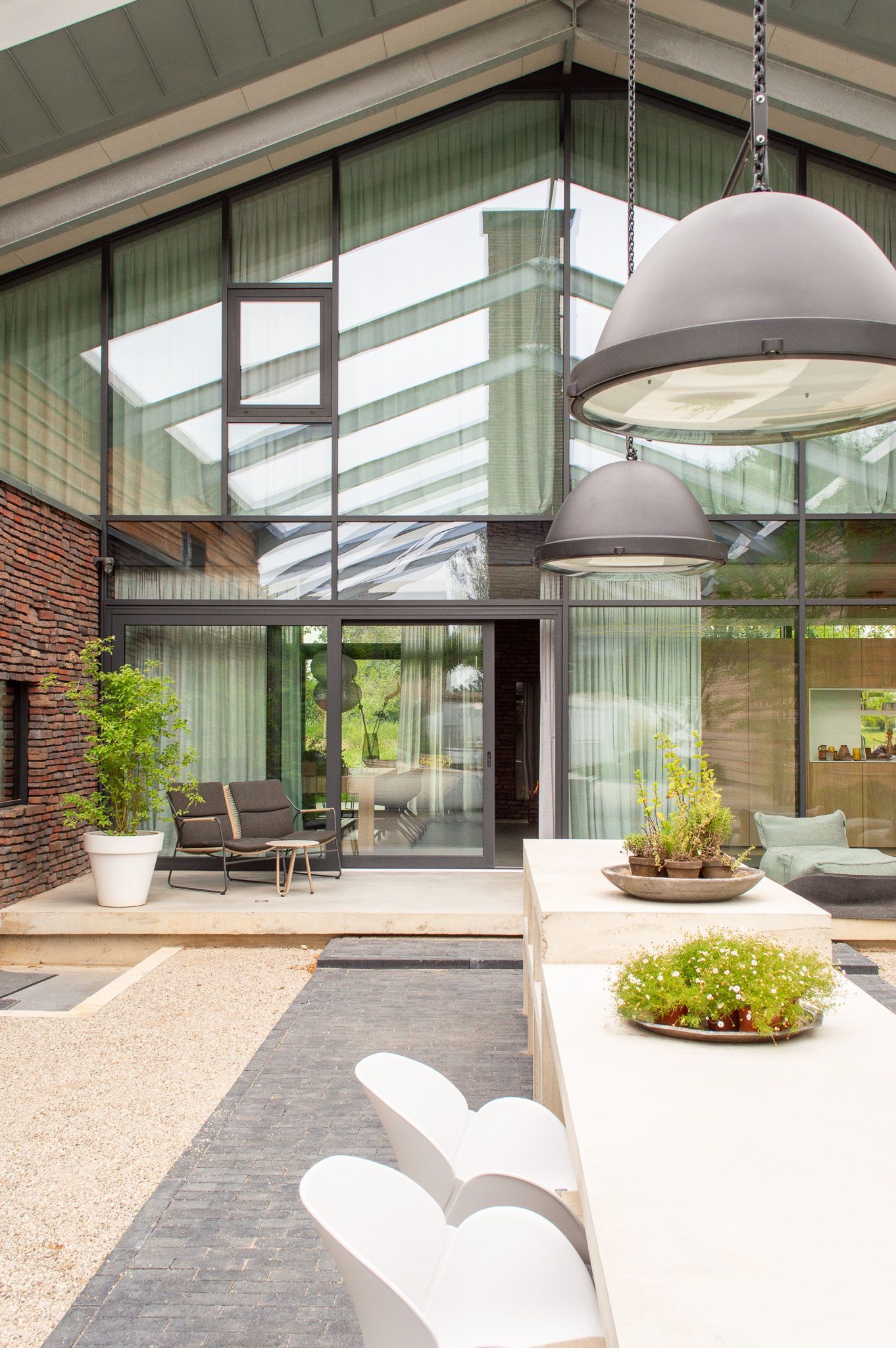 Een groot huis met een tafel en stoelen ervoor.