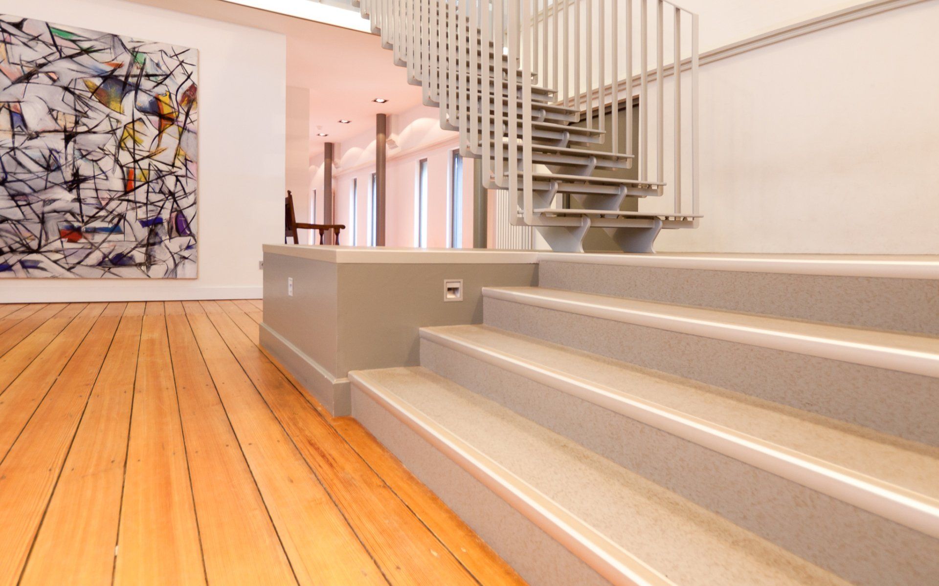 Een trap met een houten vloer en een schilderij aan de muur