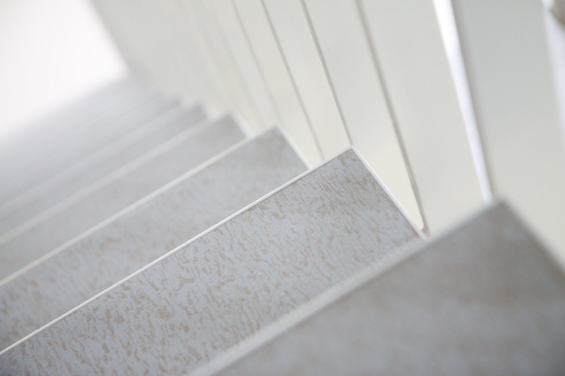 Een close-up van een trap met een witte leuning.