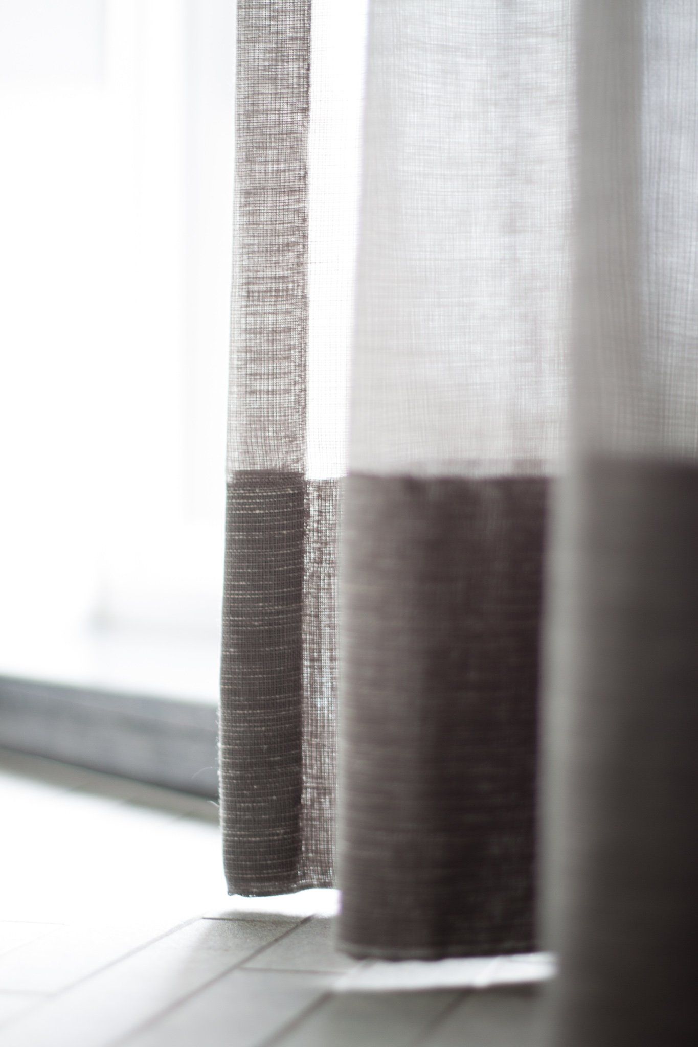 Een close-up van een paar gordijnen die aan een raam hangen.