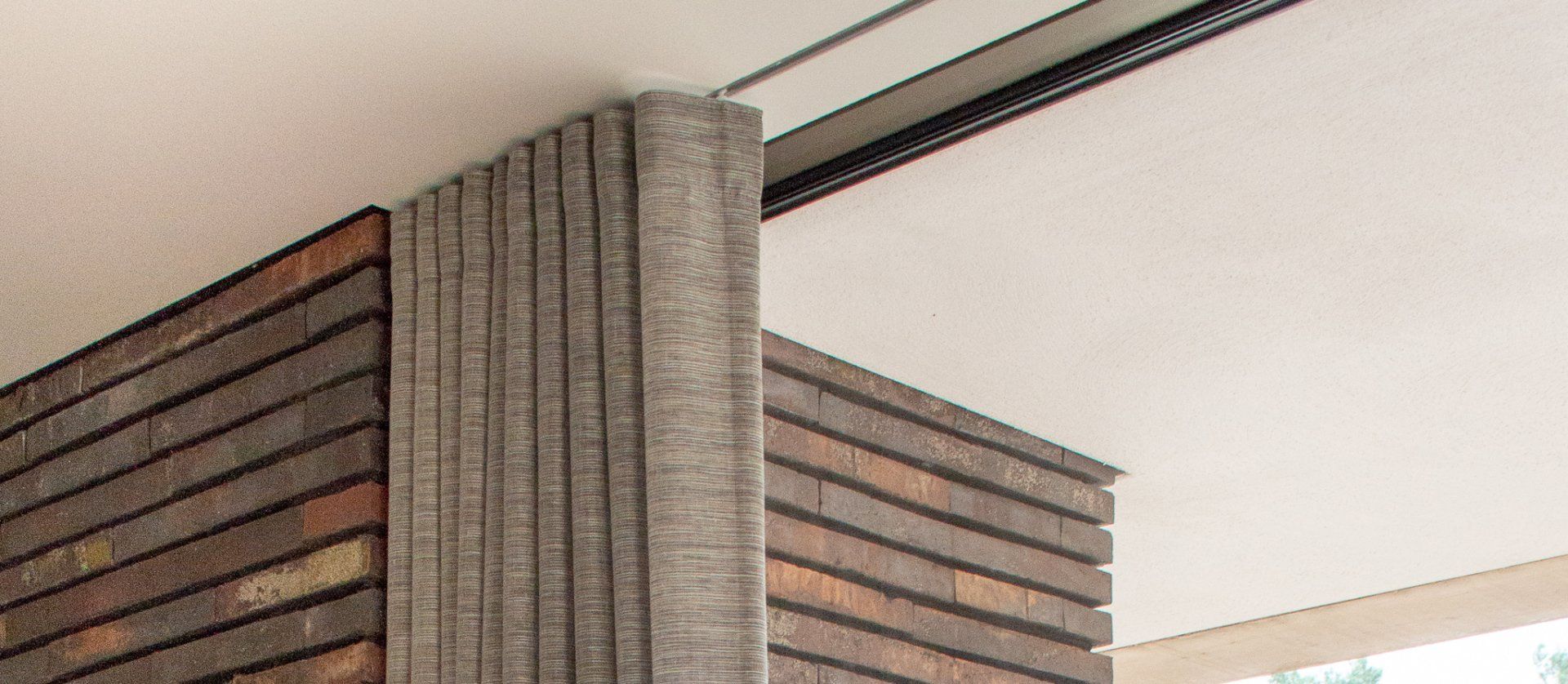 Een close-up van een bakstenen muur met een plafond in een gebouw.