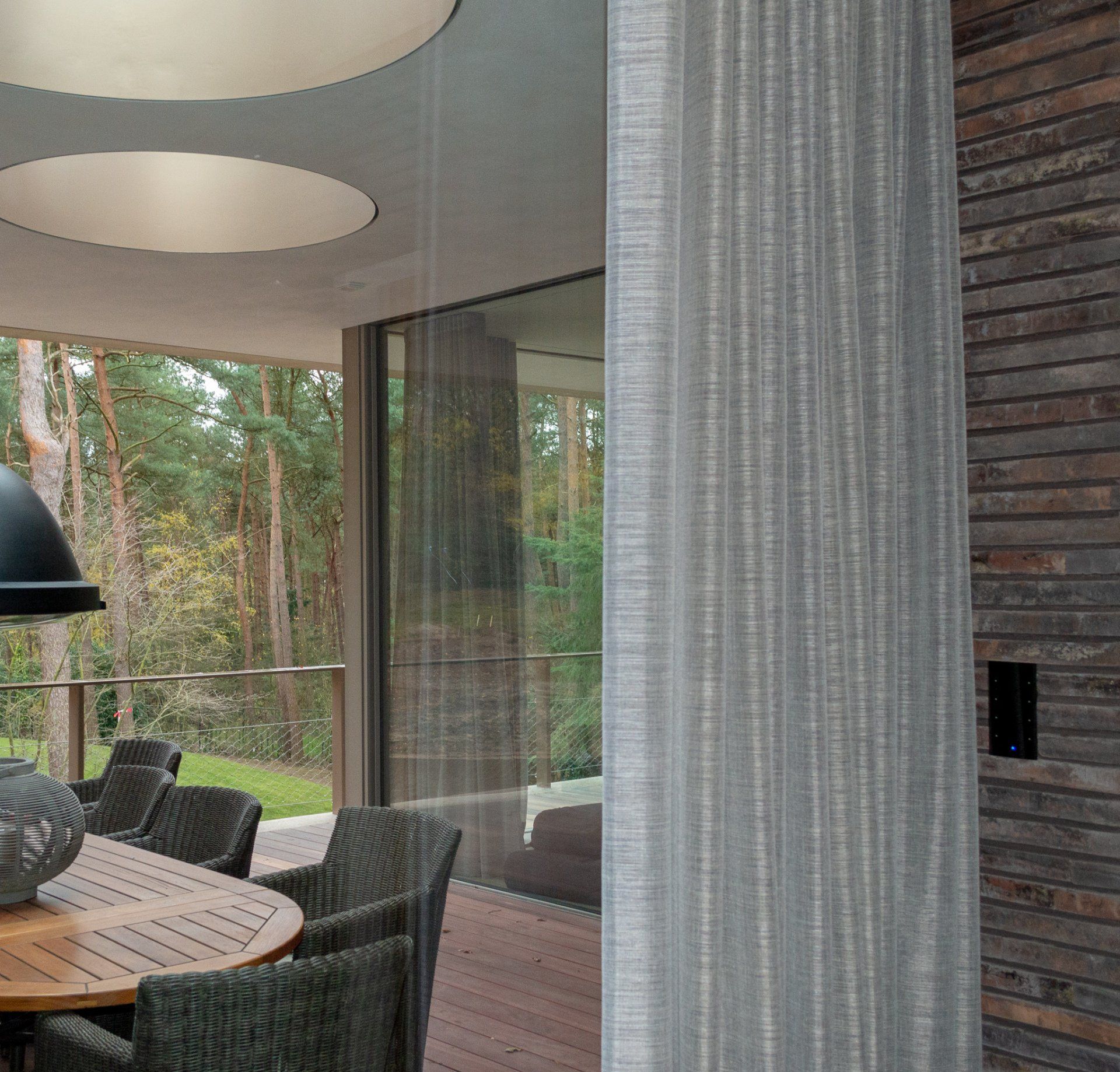 Een eetkamer met rieten stoelen en een tafel