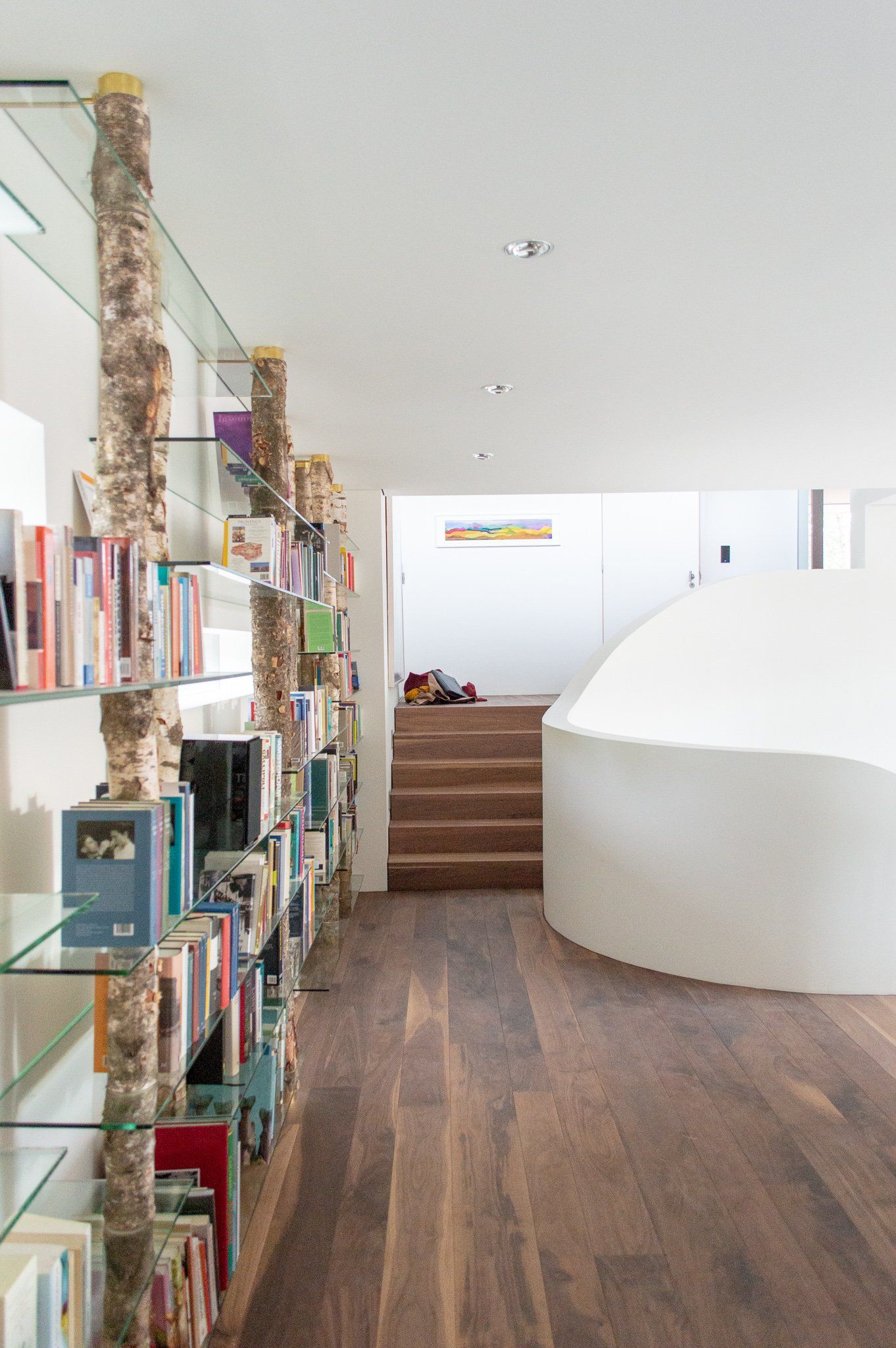 Een gang met een wenteltrap en planken vol boeken