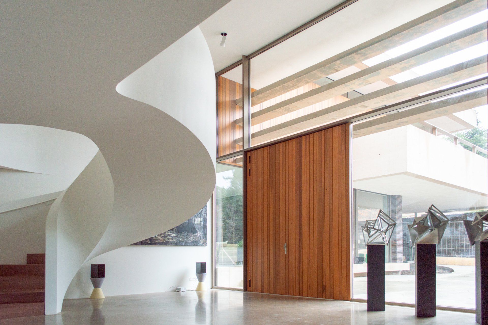 Een grote kamer met een wenteltrap en een houten deur