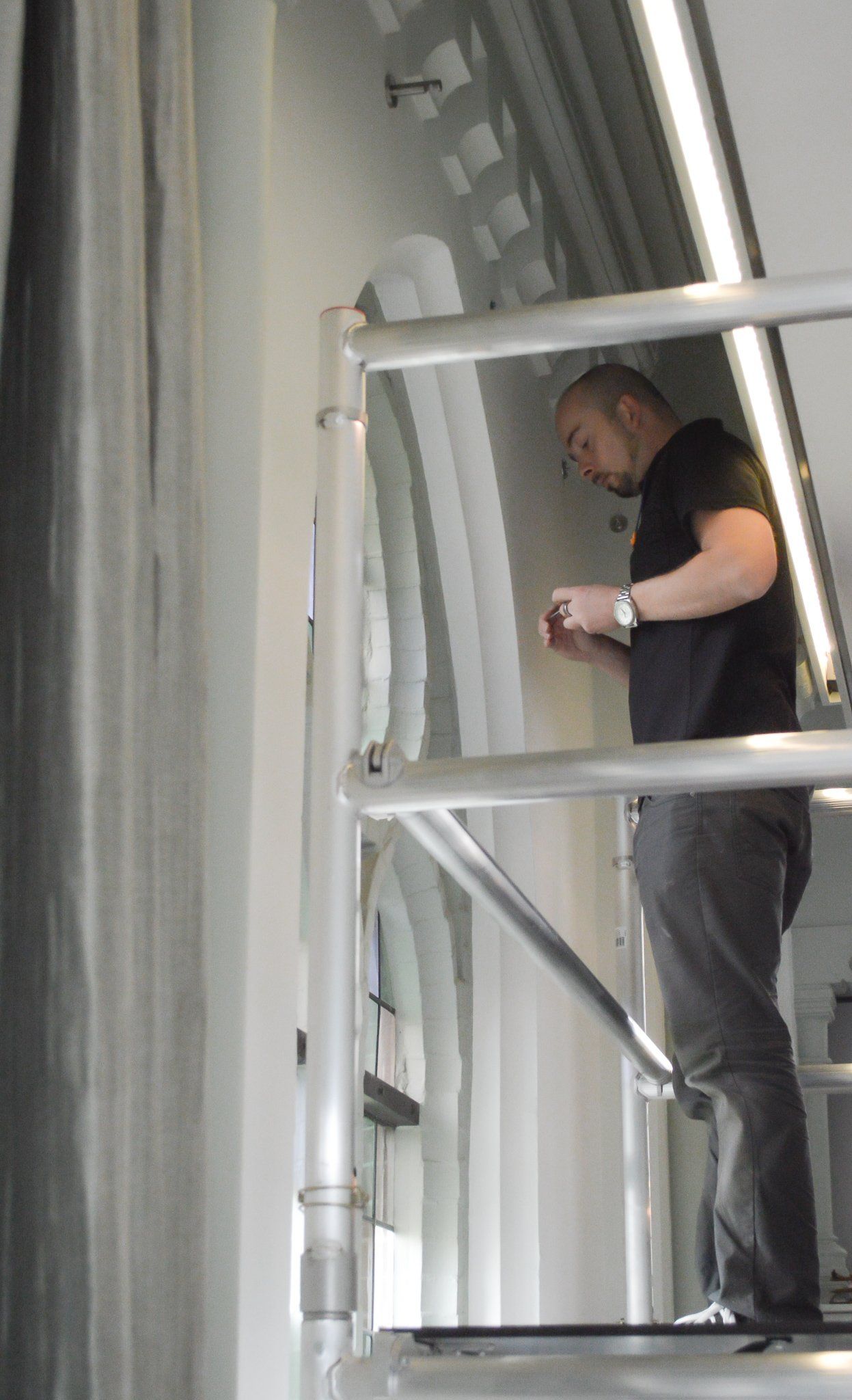 Een man die op een steiger staat en naar iets neerkijkt