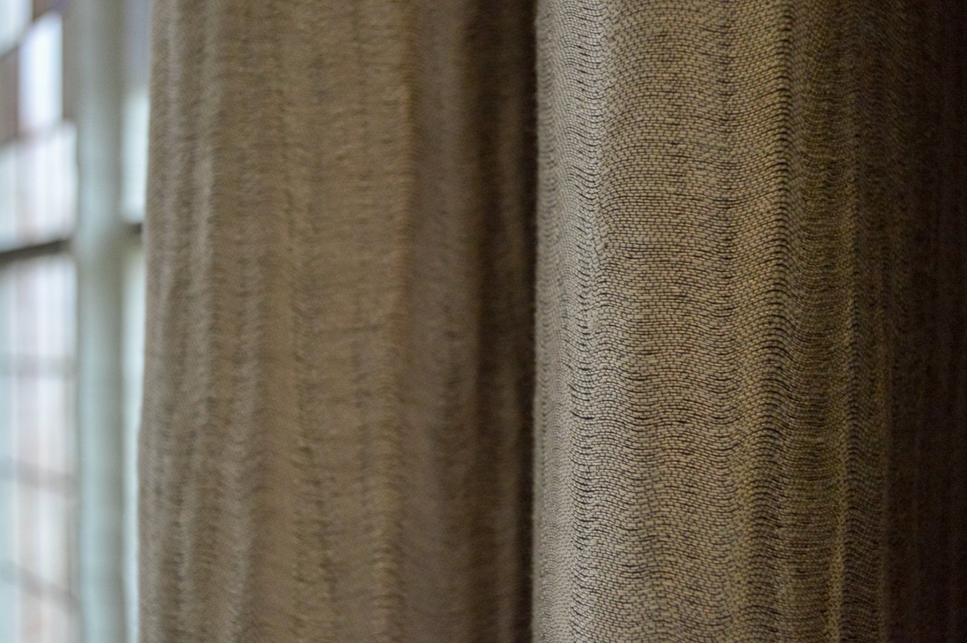 Een close-up van een paar gordijnen die aan een raam hangen.