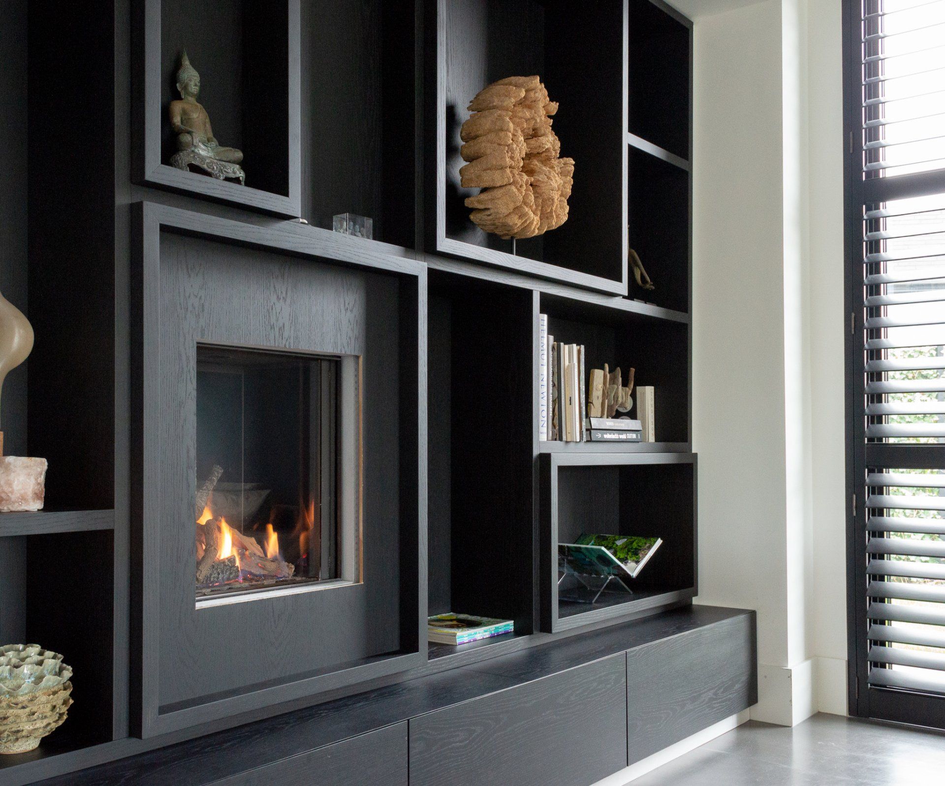 Een woonkamer met open haard en veel planken