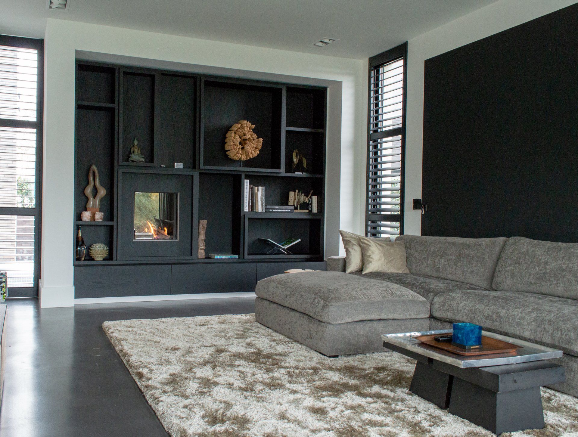 Een woonkamer met een hoekbank en een vloerkleed