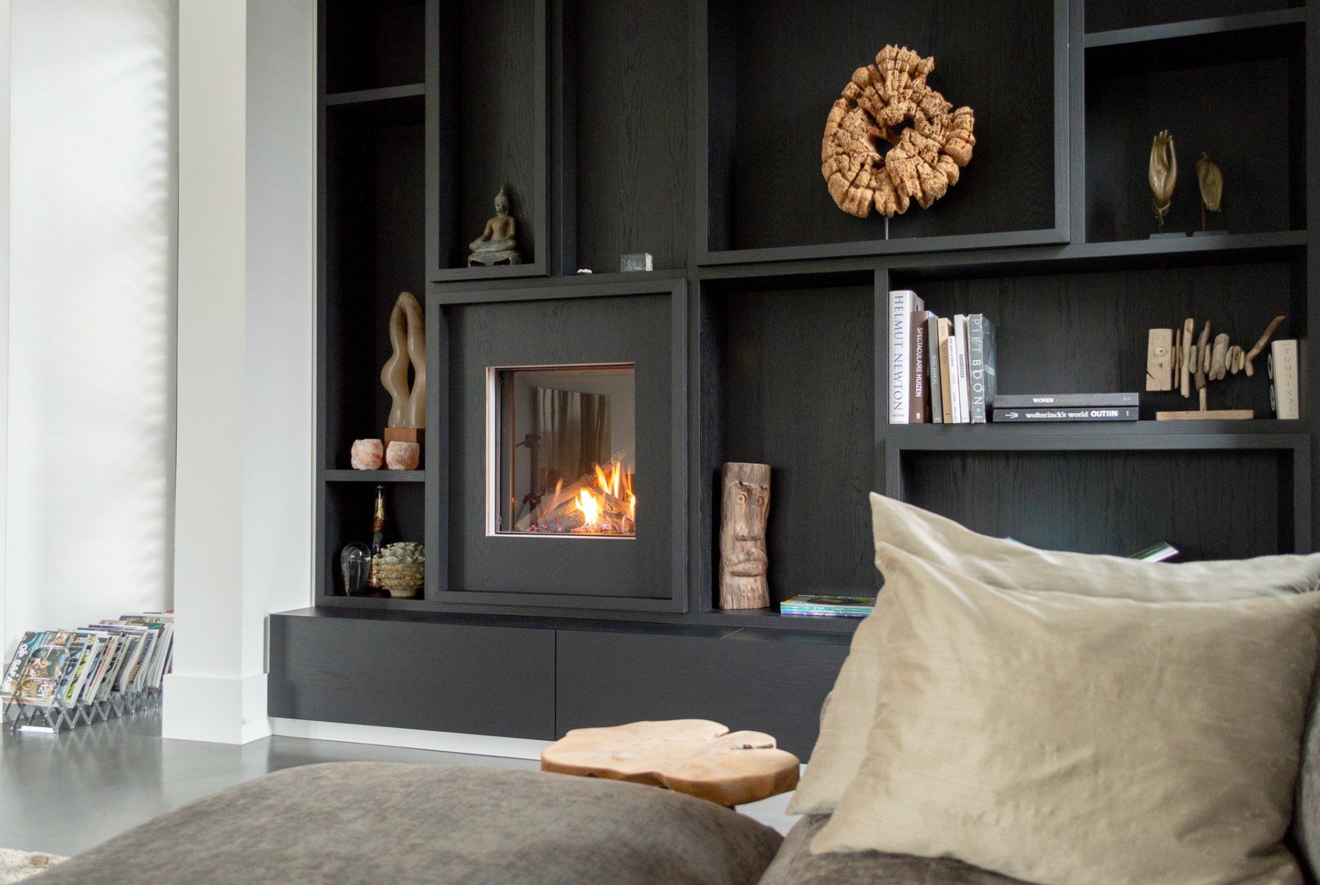 Een woonkamer met open haard en boekenplanken