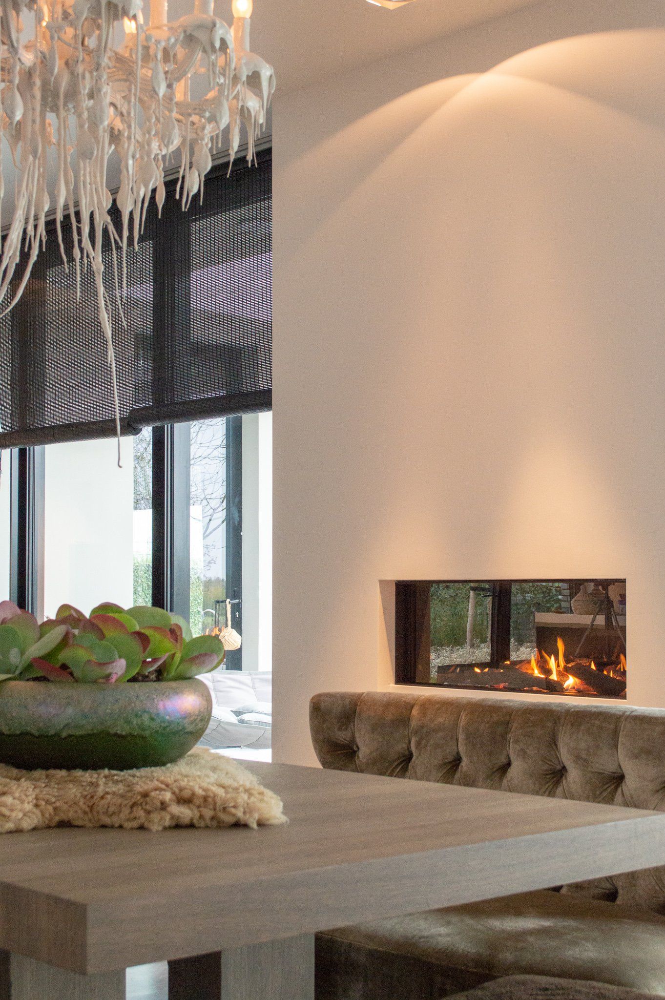 Een eetkamer met een tafel, stoelen en een open haard