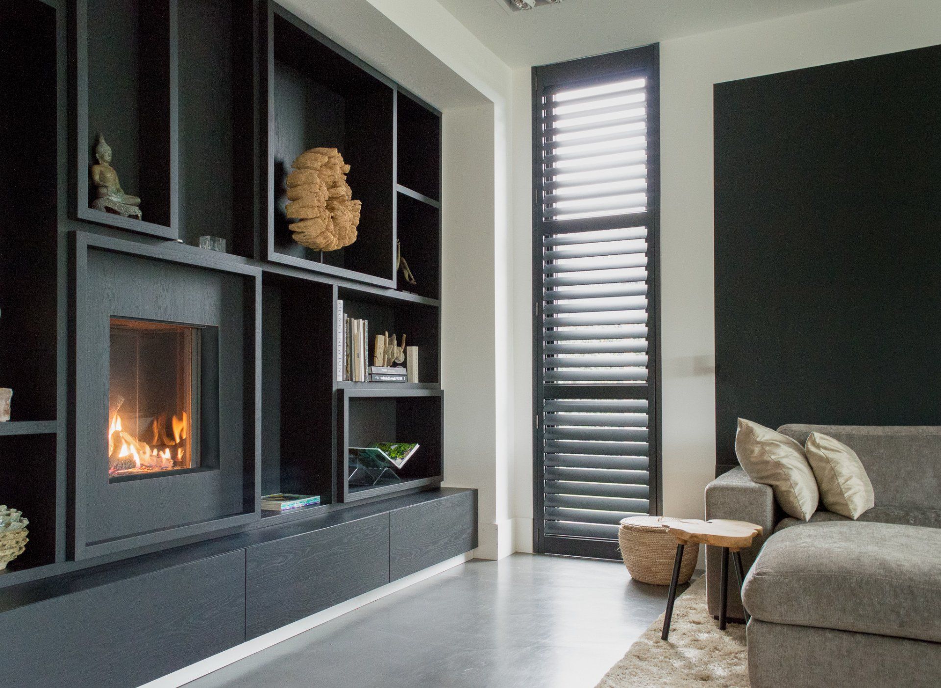 Een woonkamer met open haard en een bank