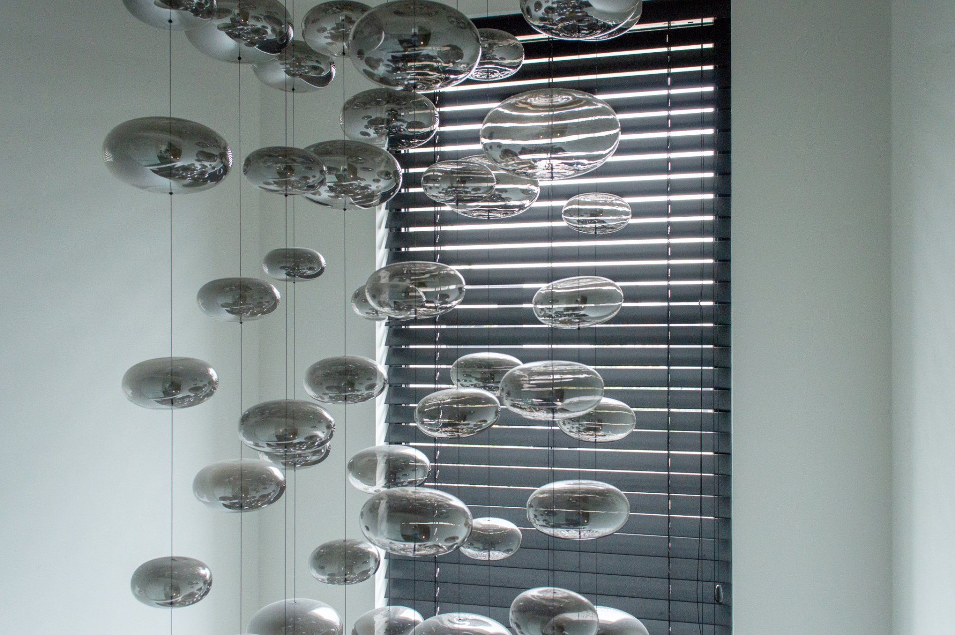 Een tros ballonnen hangt aan het plafond voor een raam