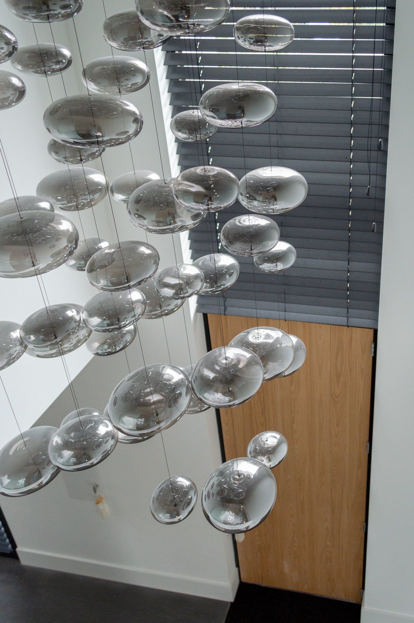 Een bos zilveren ballonnen hangt aan het plafond