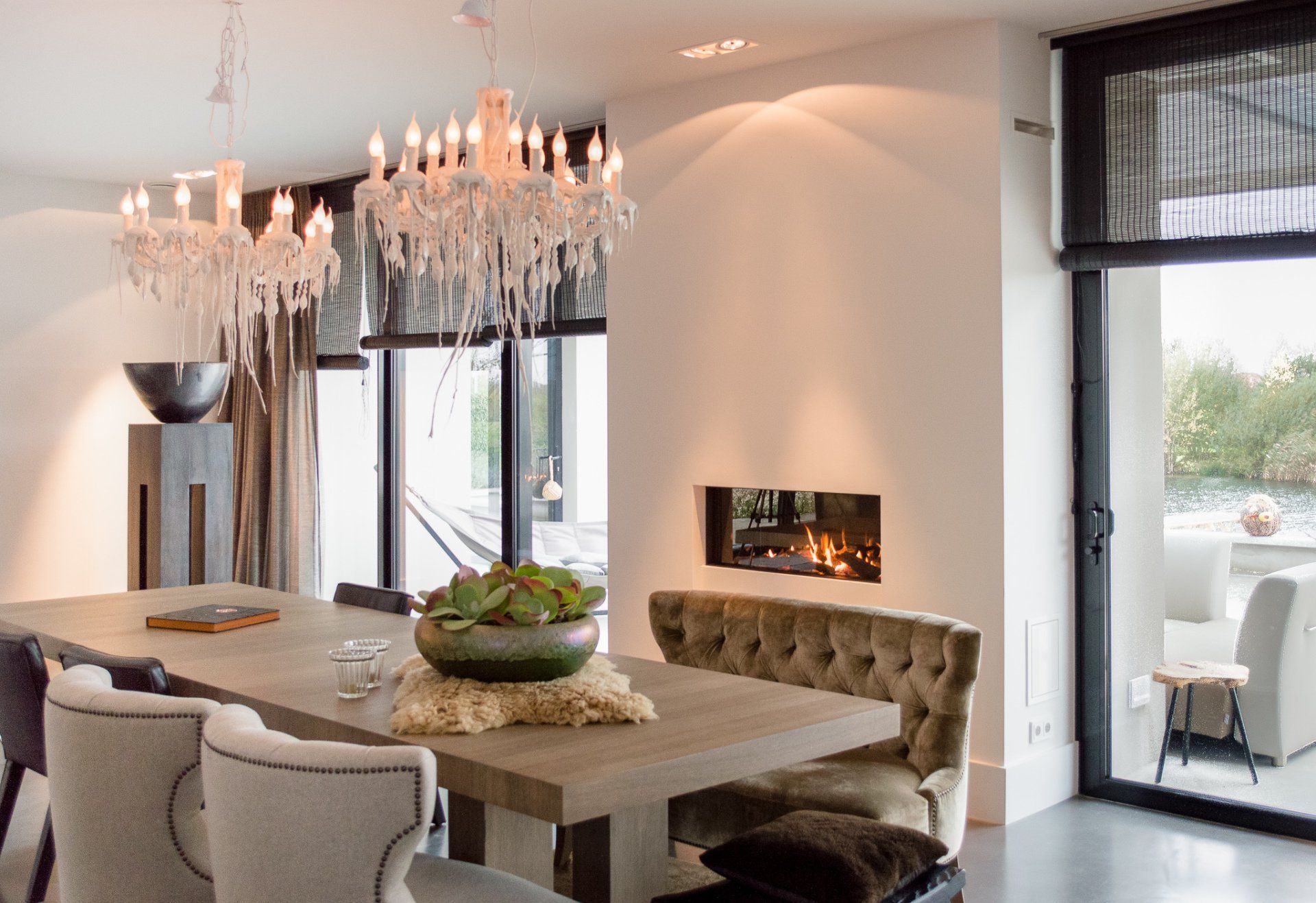 Een eetkamer met een tafel, stoelen en een open haard