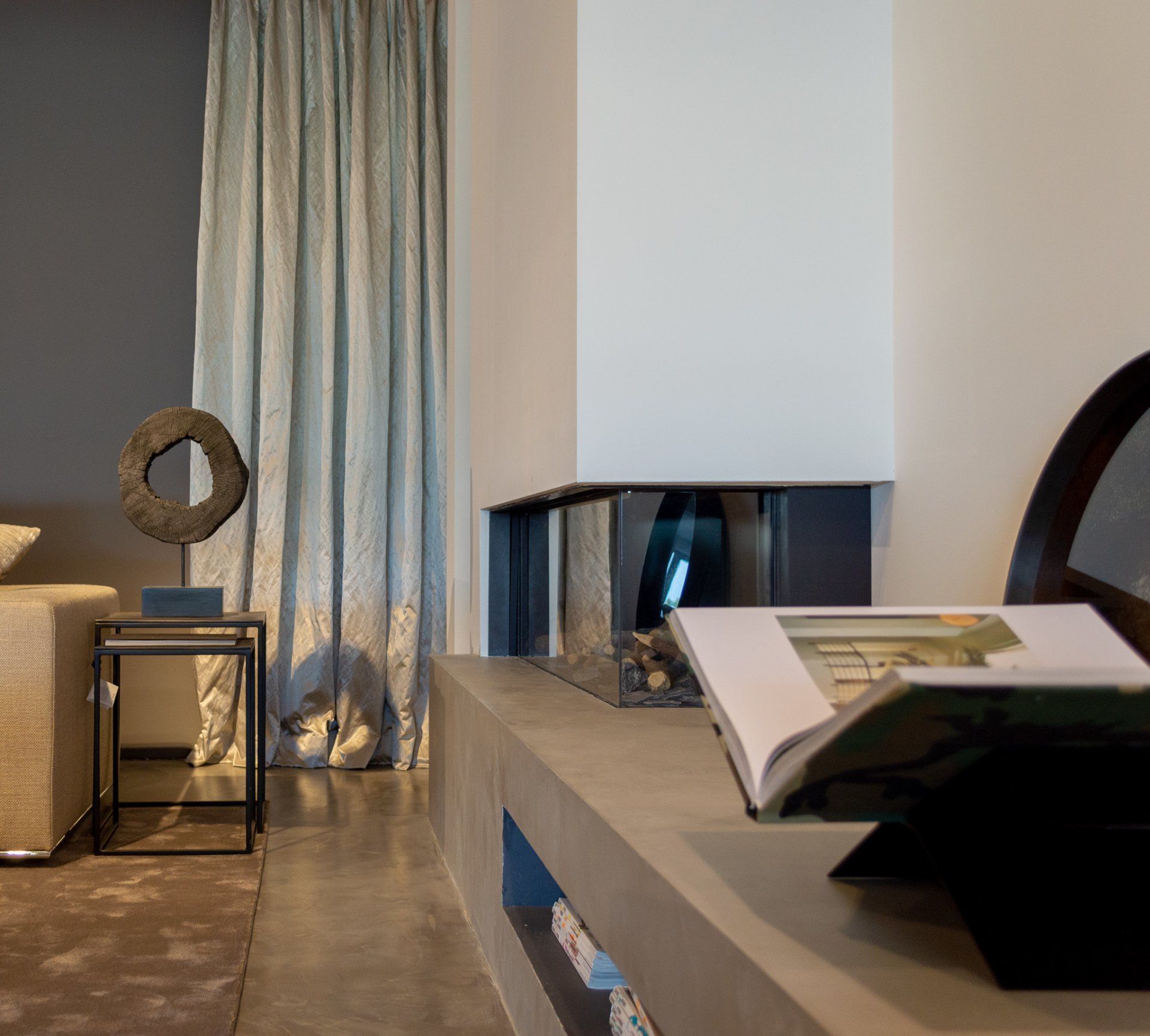 Een woonkamer met een open haard en een boek op een tafel