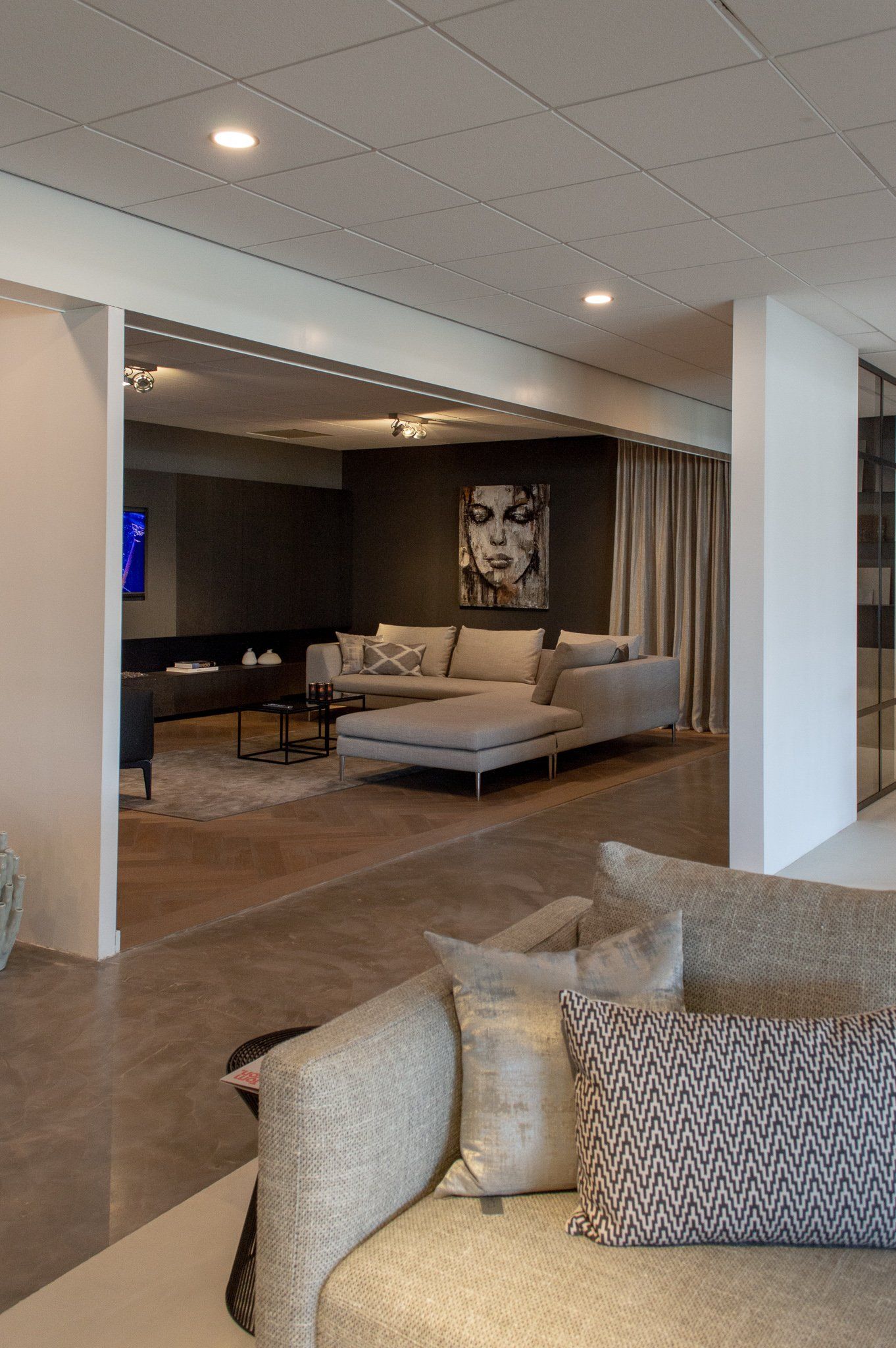 Een woonkamer met een bank en een schilderij aan de muur