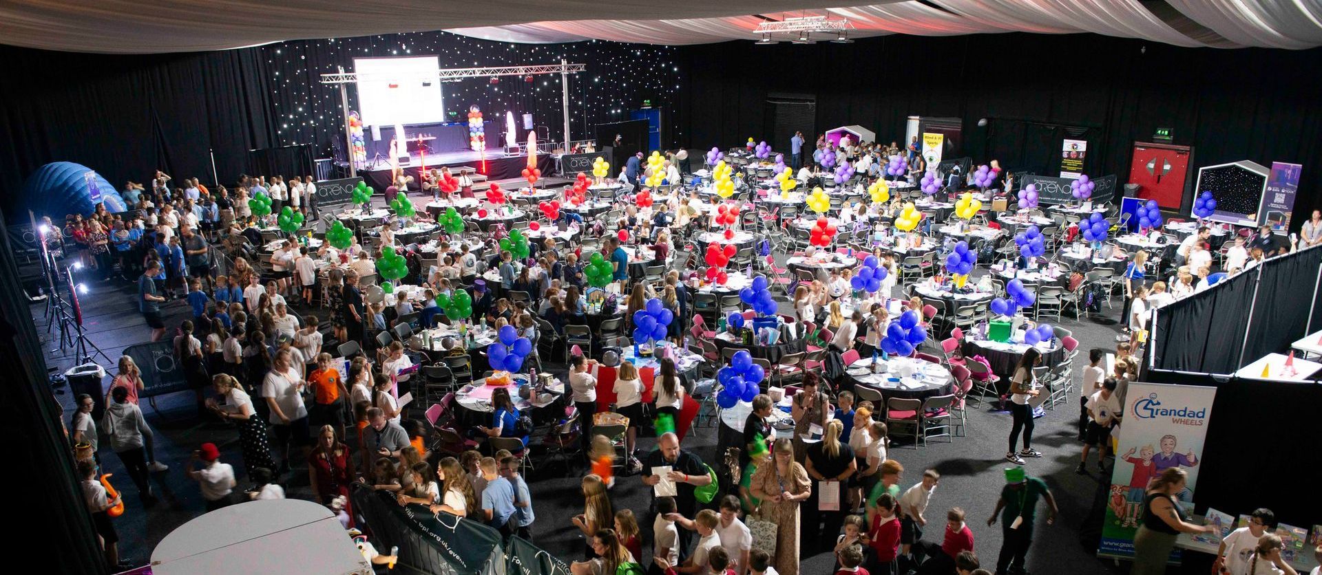 Overview of the Metrodome venue with the stage set up and all the pupils attending the event.