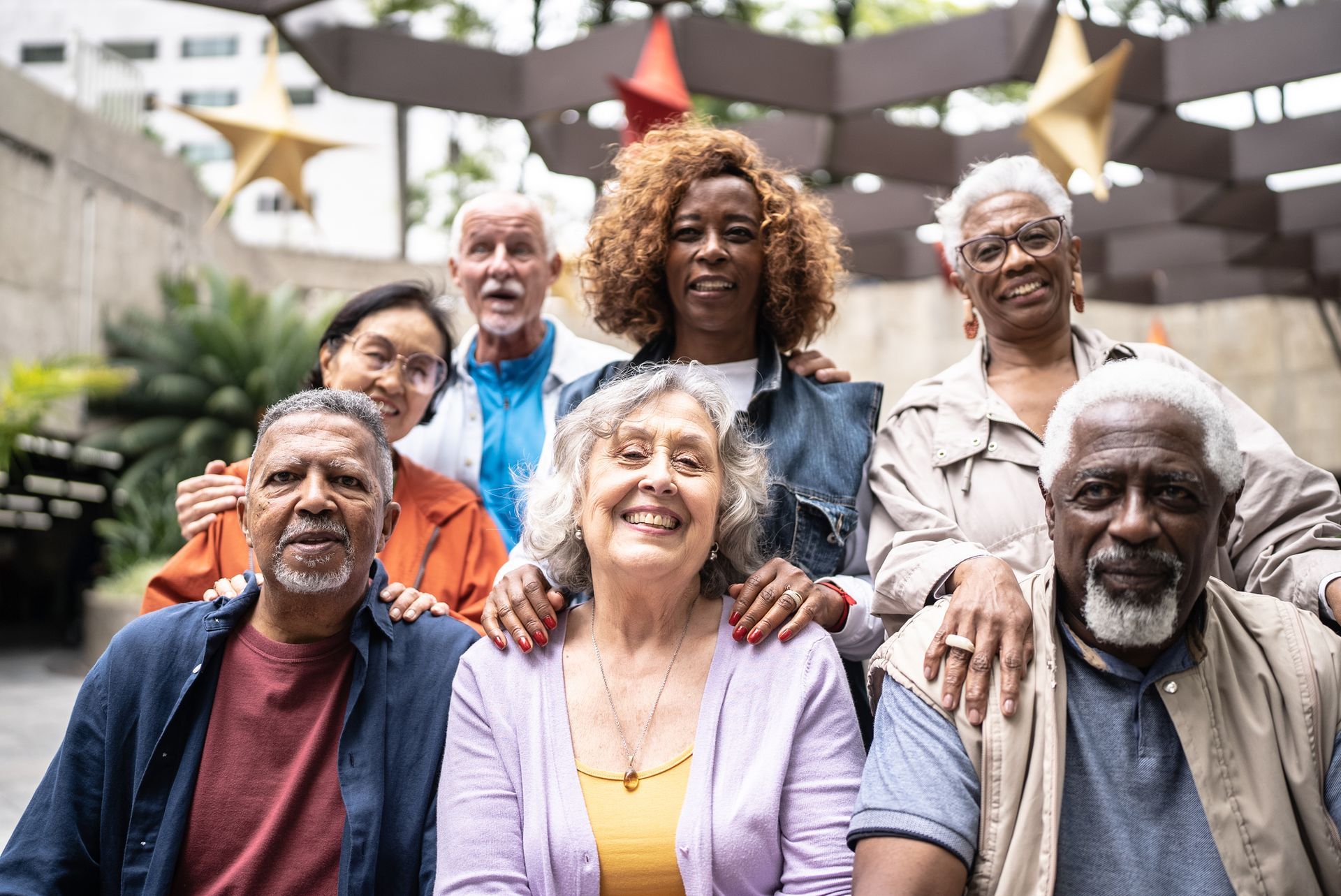 A group of elderly people are posing for a picture in a park.