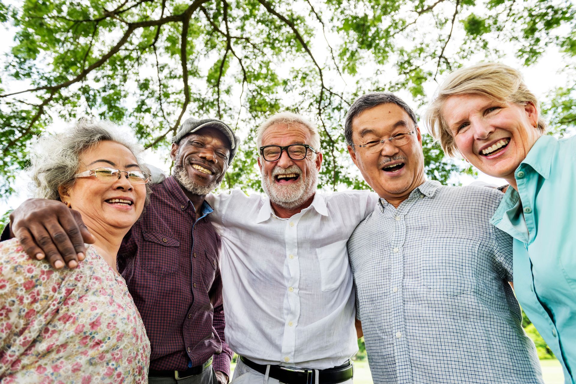 A group of elderly people are posing for a picture in a park.