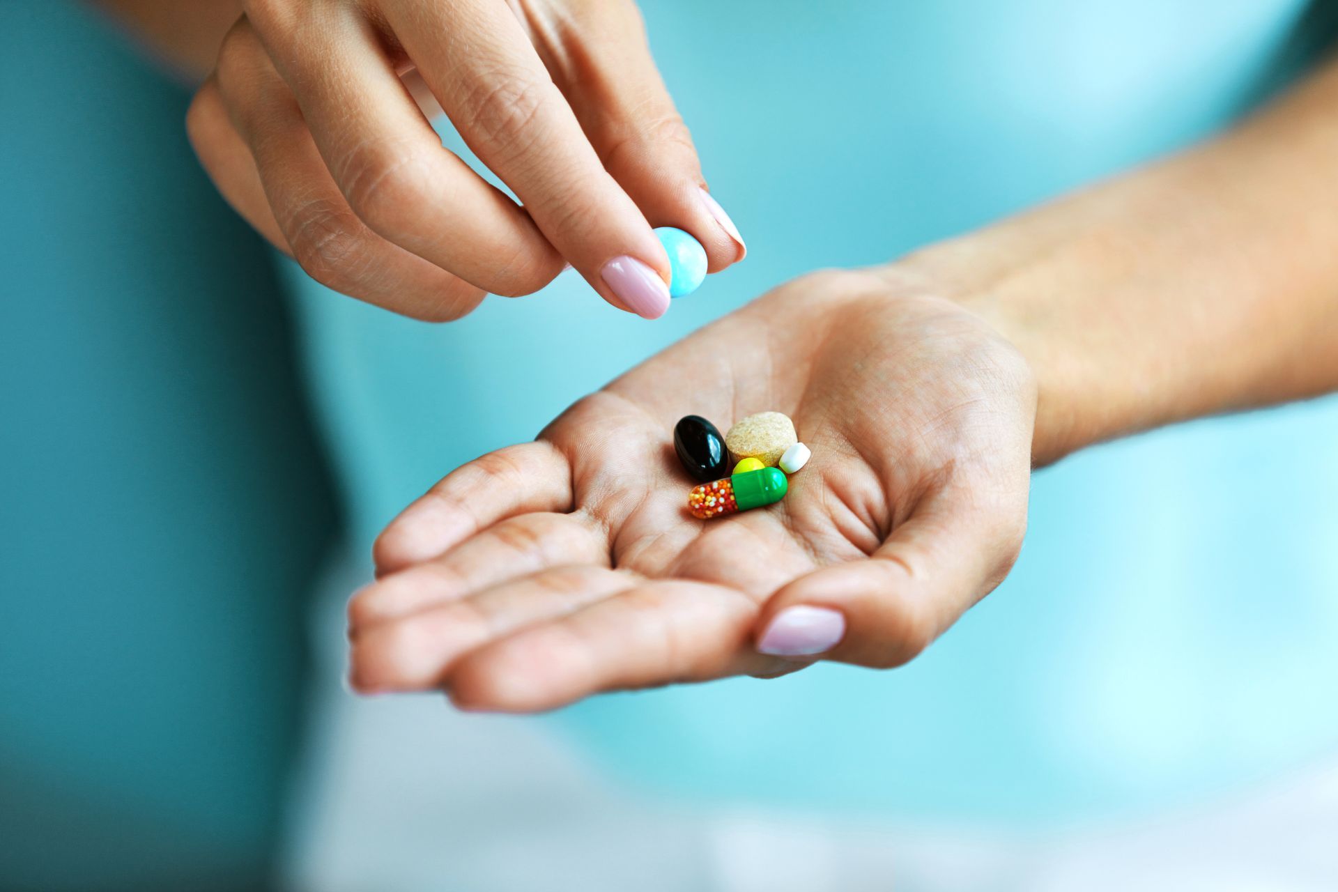 A woman is holding some vitamins on her hand