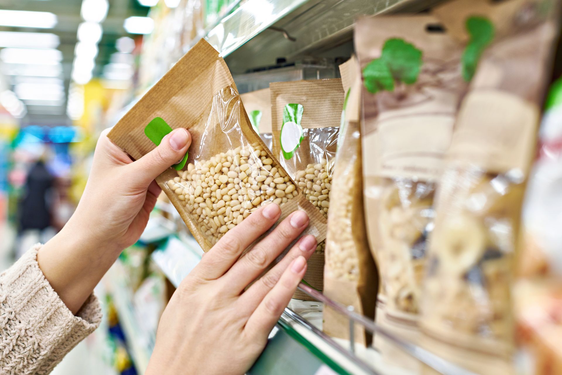 Buyer hands over the packaging of pine nuts in the store.