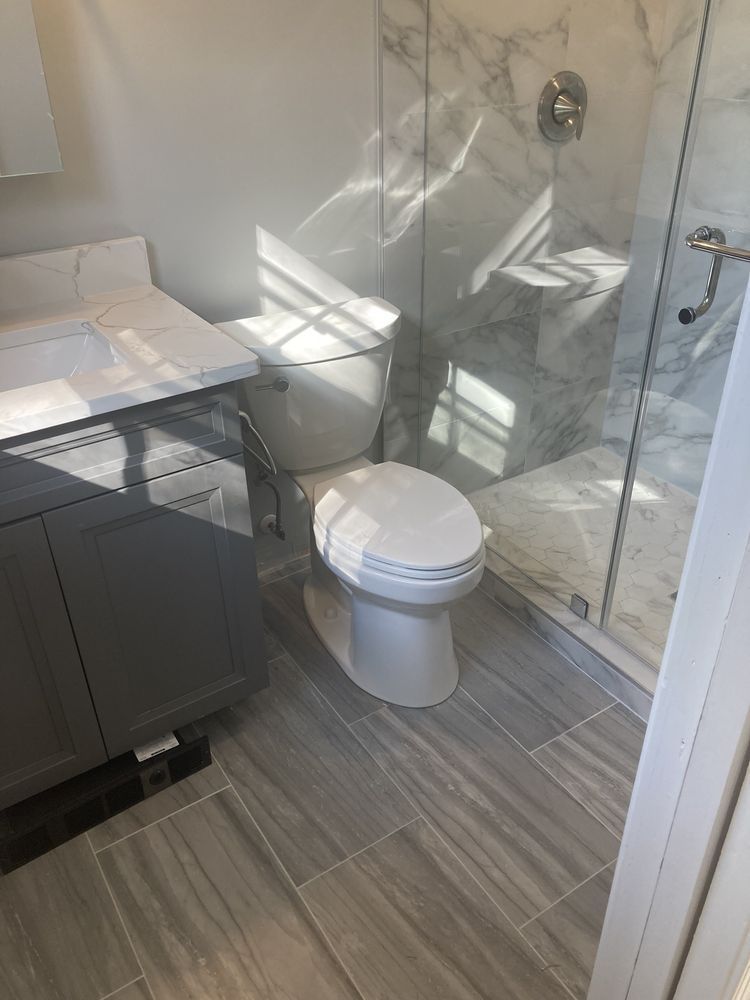 A bathroom with a toilet , sink , and shower.