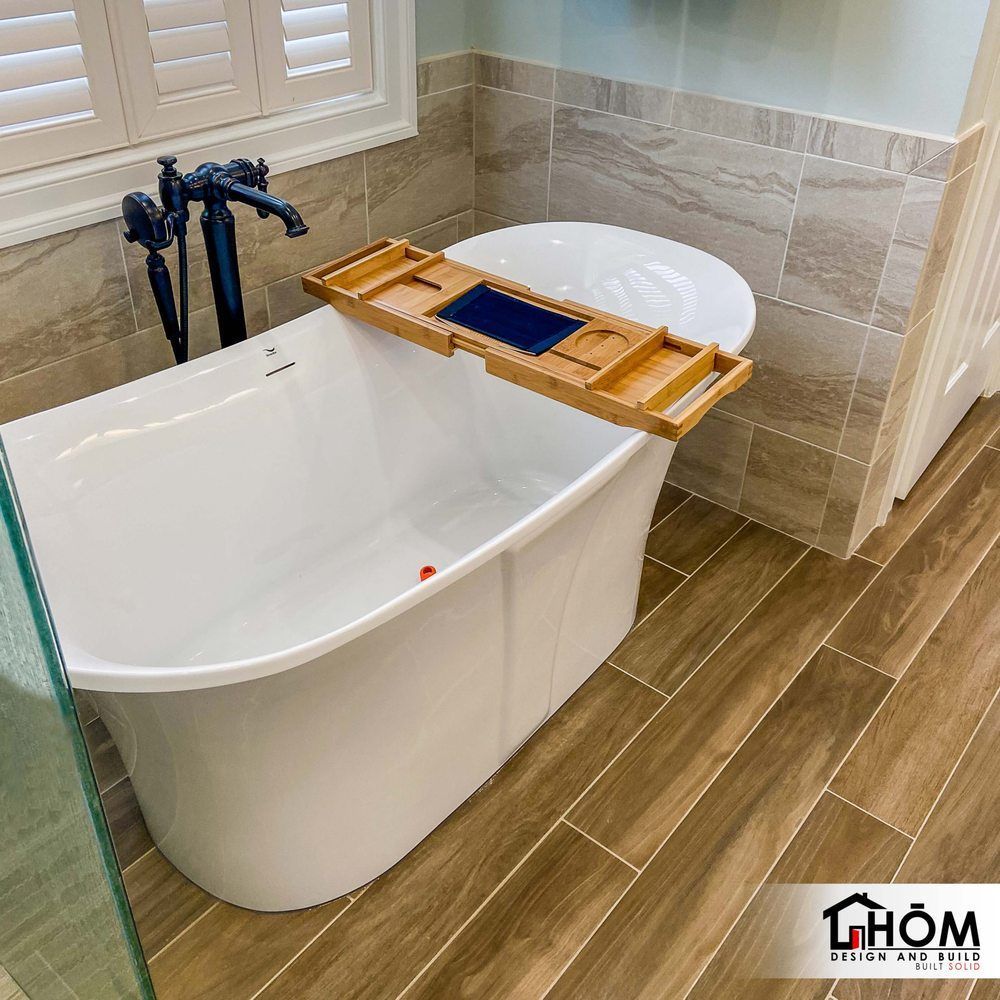 A bathtub with a wooden tray on top of it in a bathroom.