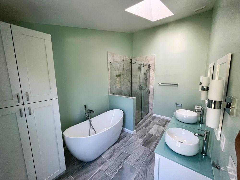 A bathroom with two sinks , a tub , and a walk in shower.