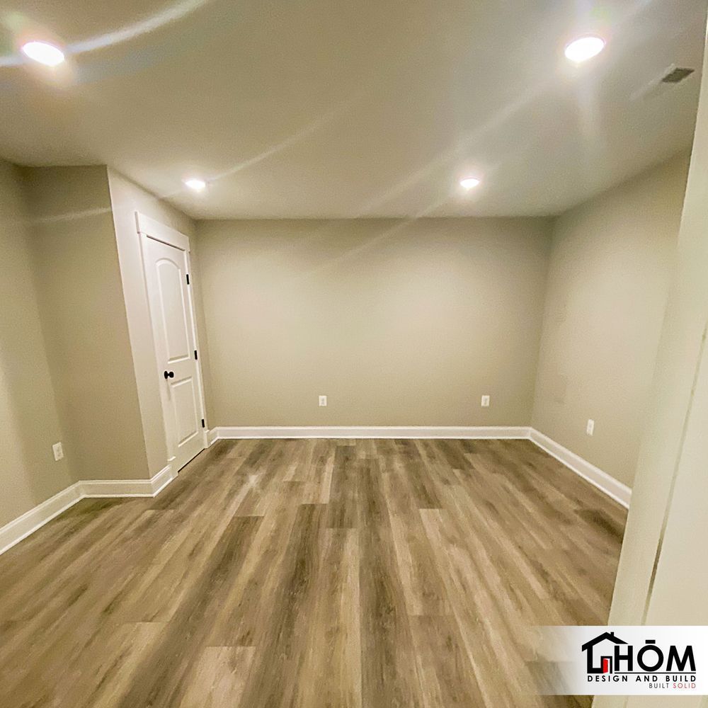 An empty room with hardwood floors and a door.