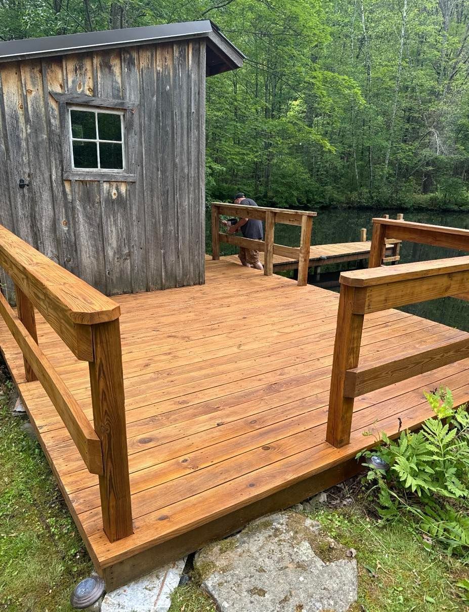 A wooden deck with a dock and a shed in the background.