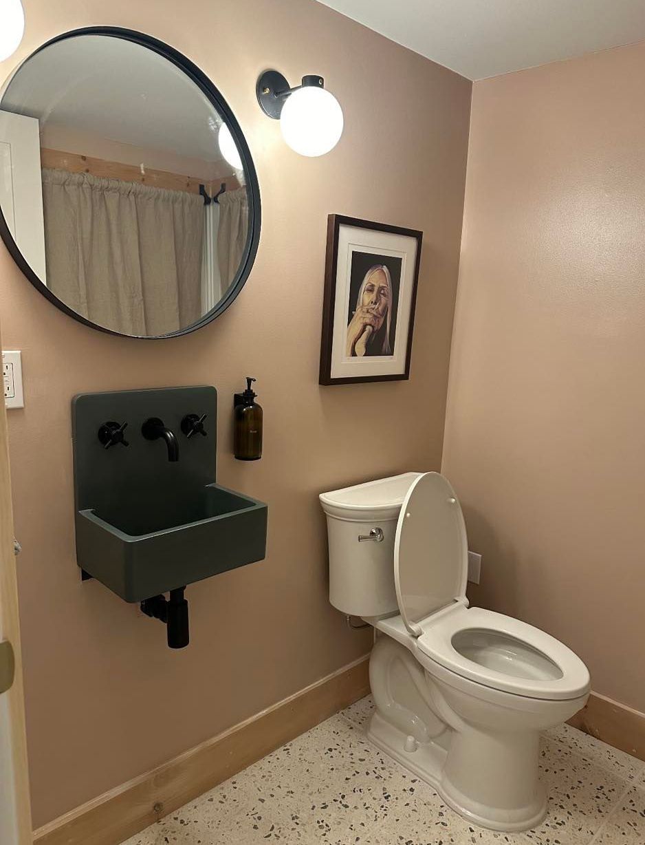 A bathroom with a toilet a sink and a mirror